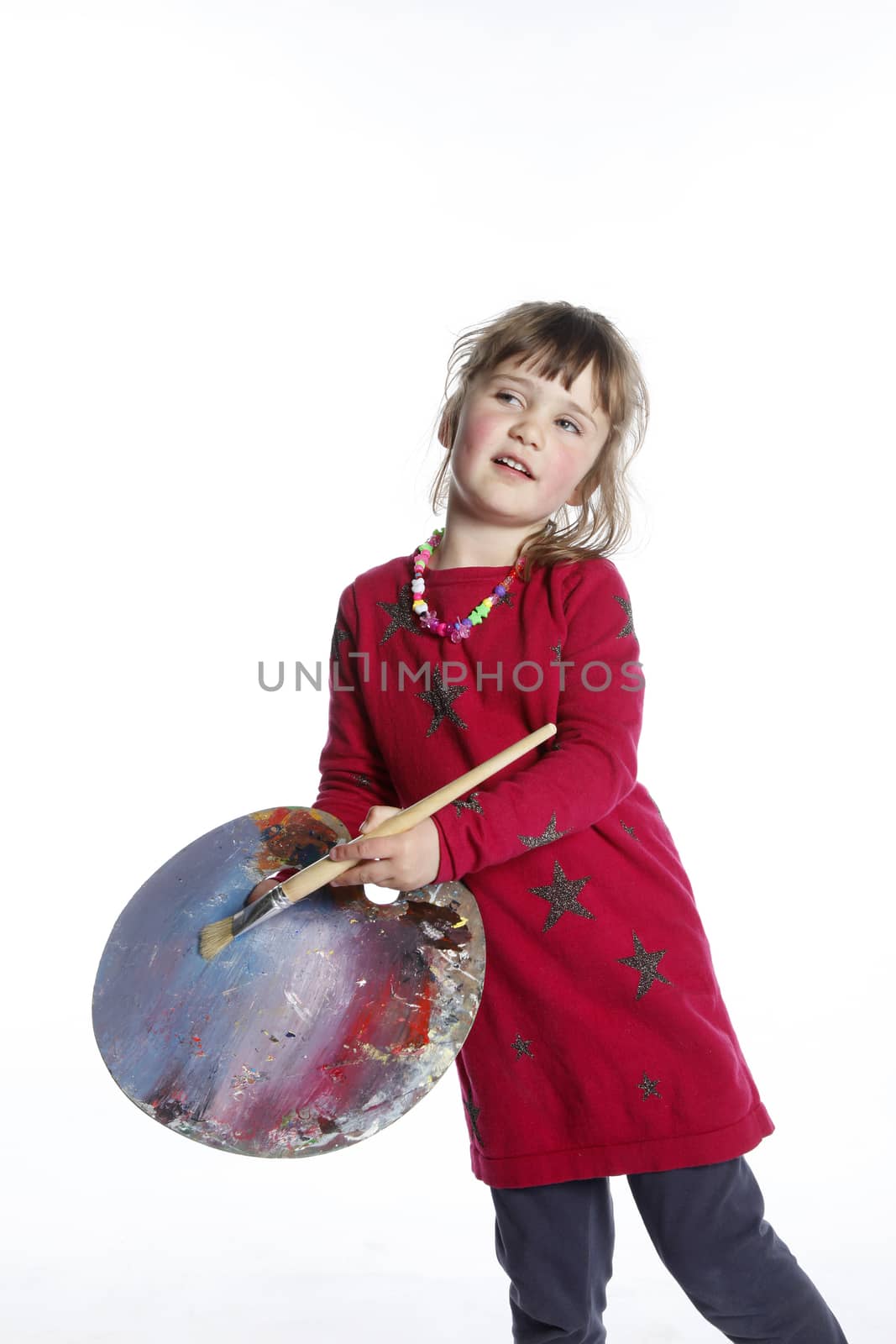 very young girl in red with brush and palette for painting in studio against white background