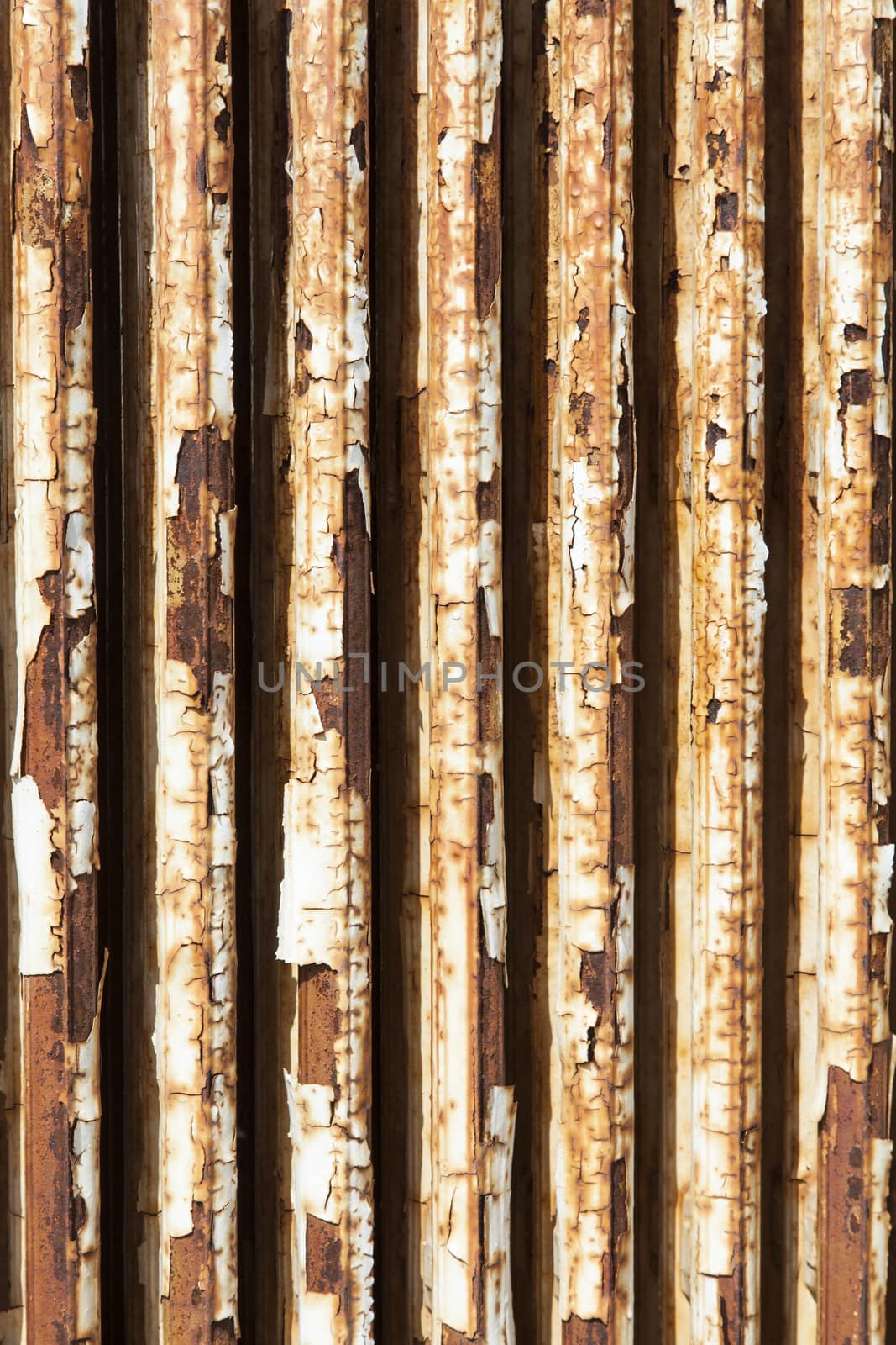 old central heating radiator with cracked white paint and rust