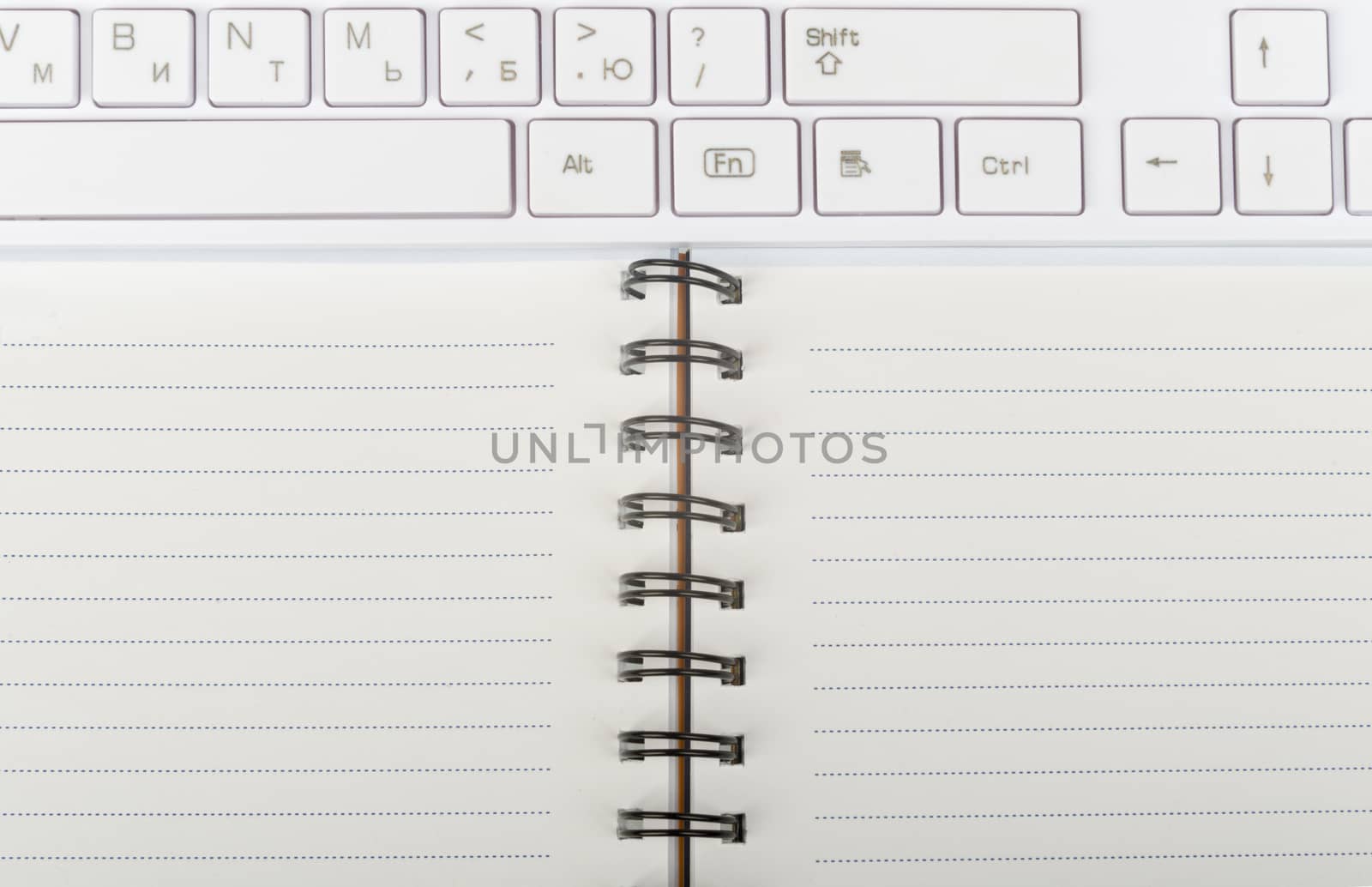 Keyboard and ring-bound notebook, close-up view