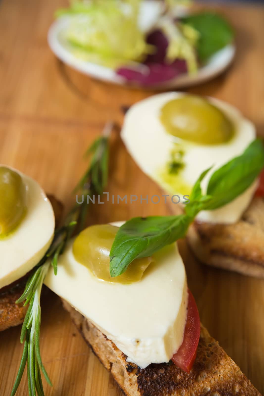 Bruschetta with tomato, mozarella and olive on wooden table 