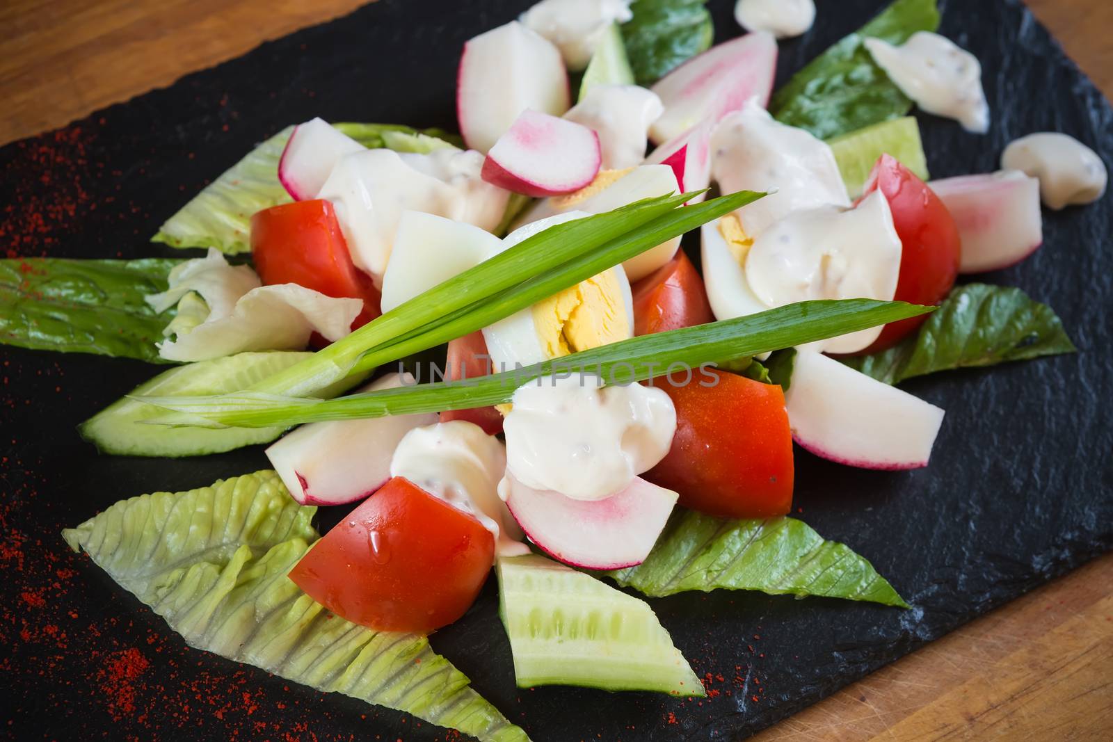 Summer salad of tomatoes, cucumbers, asparagus, young green peas dressed with olive oil and watercress salad