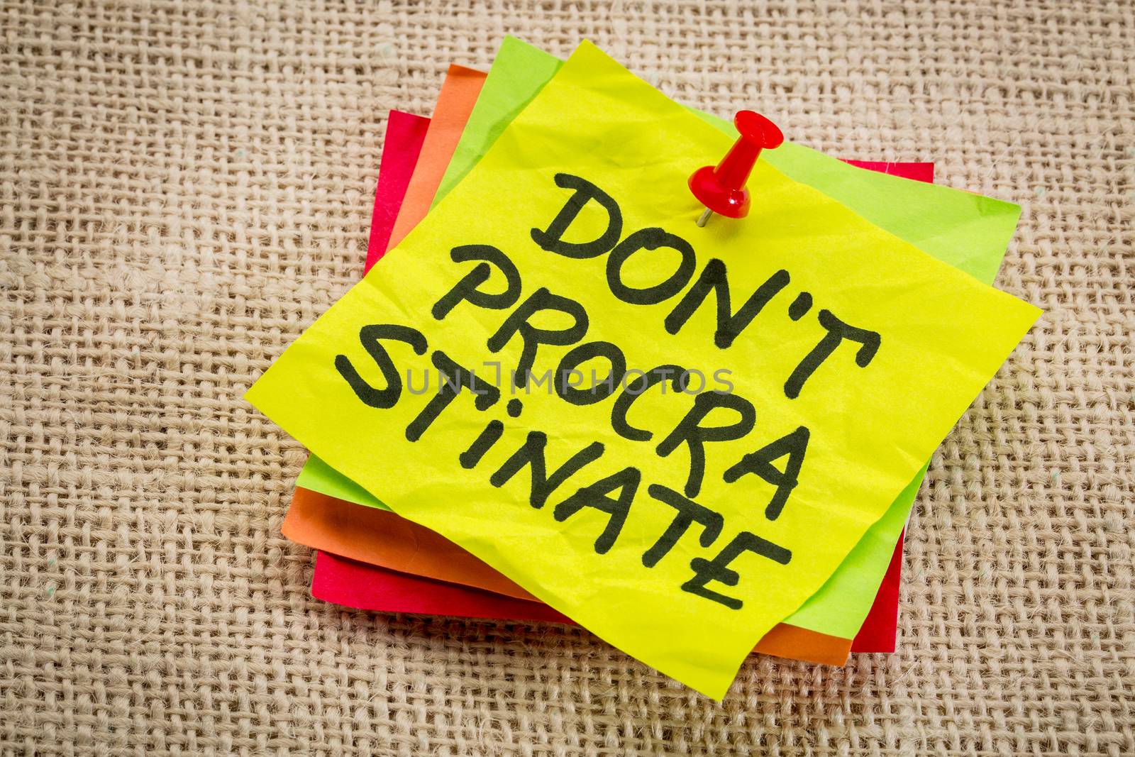 do not procrastinate reminder on a yellow sticky note