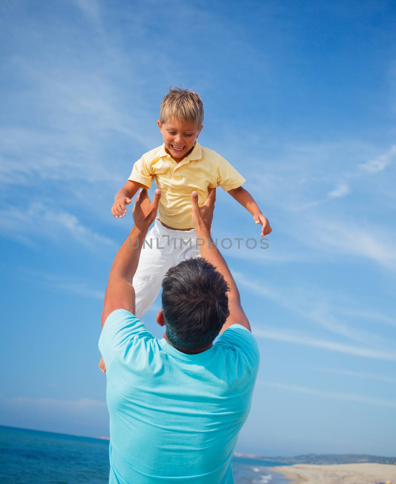 Father and son playing at the beach in the day time