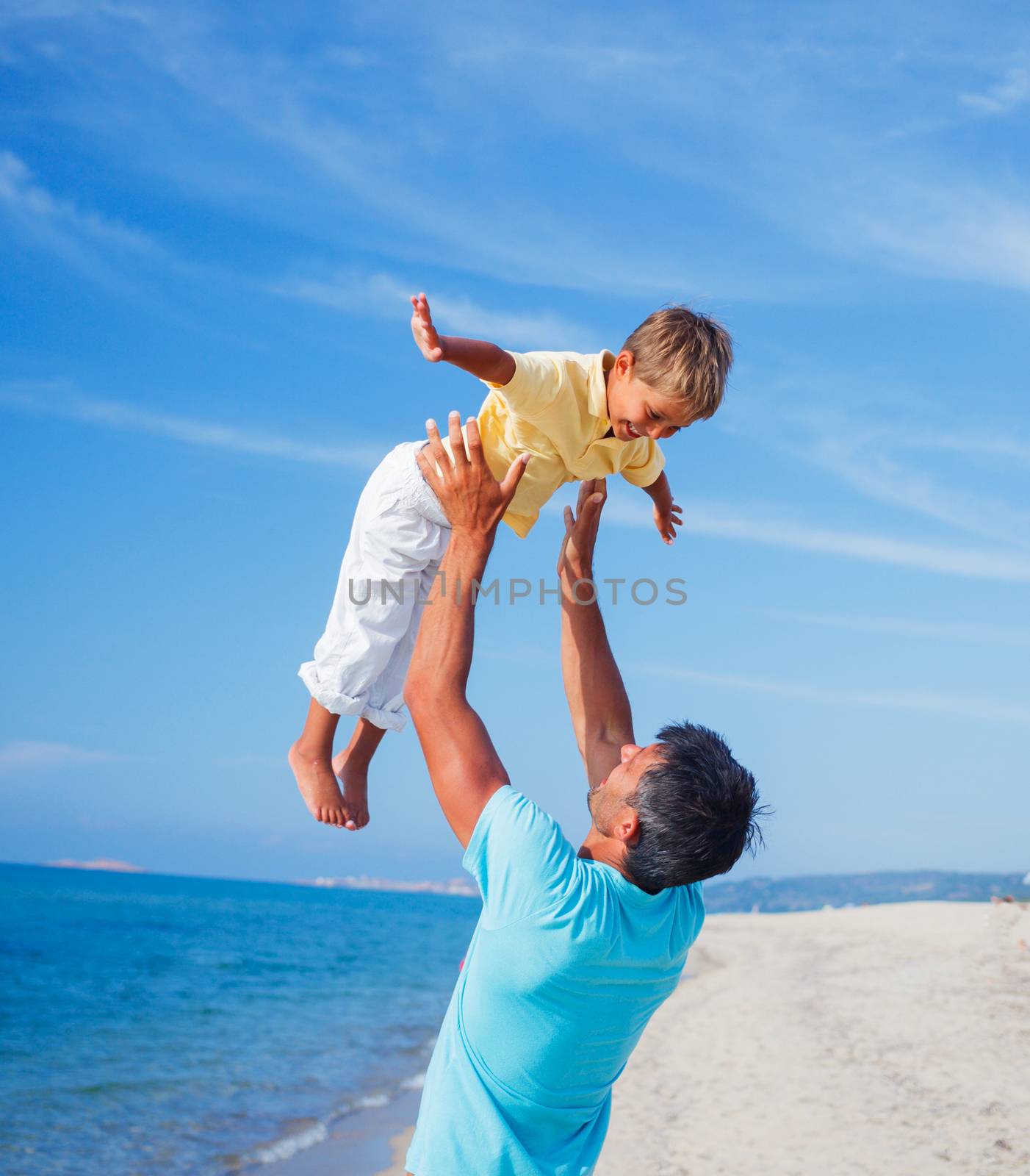 Father and son playing at the beach in the day time