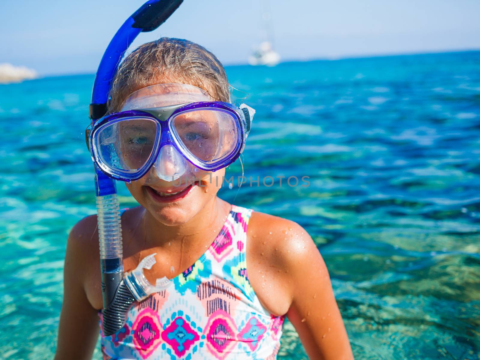 Happy cute girl wearing snorkeling mask ready to dive in the sea