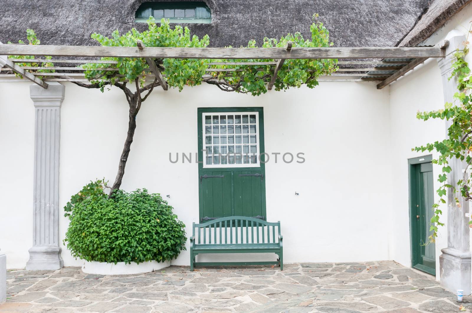 Grape vine, bench and window with barn doors at the historic  Drosdy, built by the Dutch East India Company in 1747