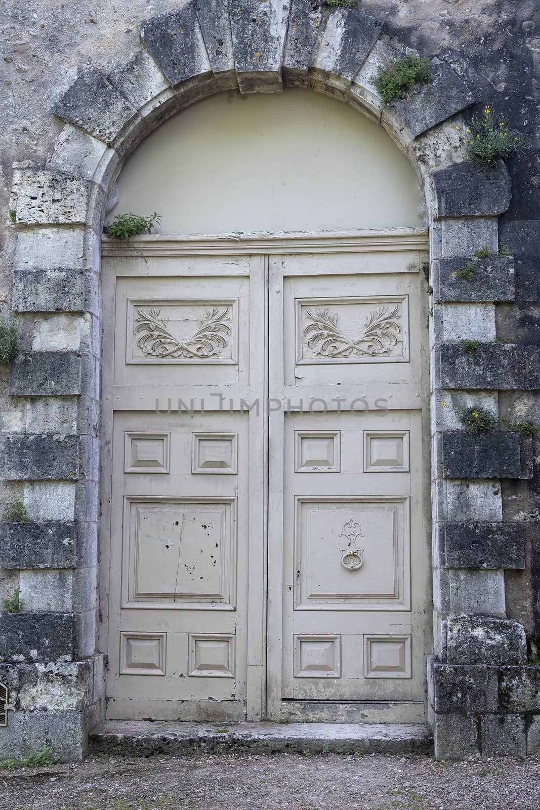 A double door in wood framed by a stone bulding