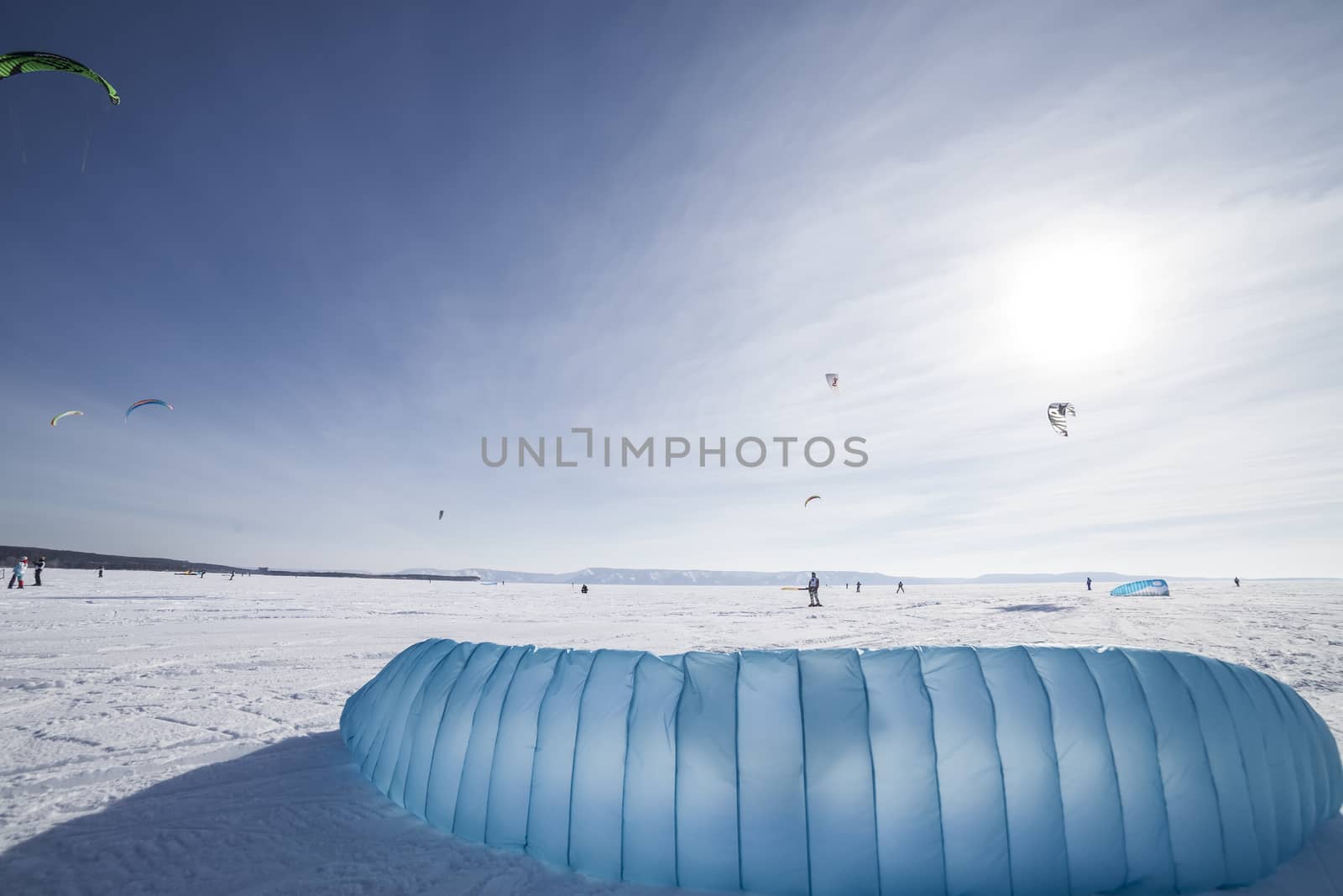 Kiteboarder with blue kite on the snow by H2Oshka