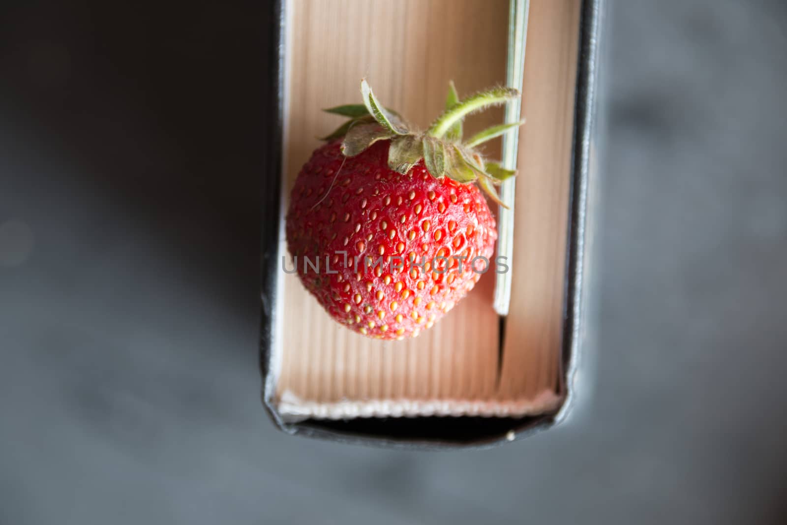 Strawberries and  cook book on a dark table. Healthy Eating.