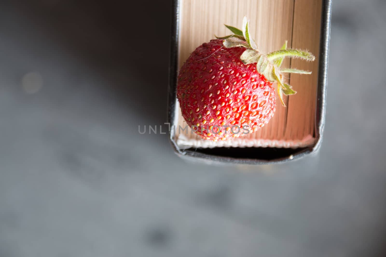 Strawberries and  cook book on a dark table. Healthy Eating. 