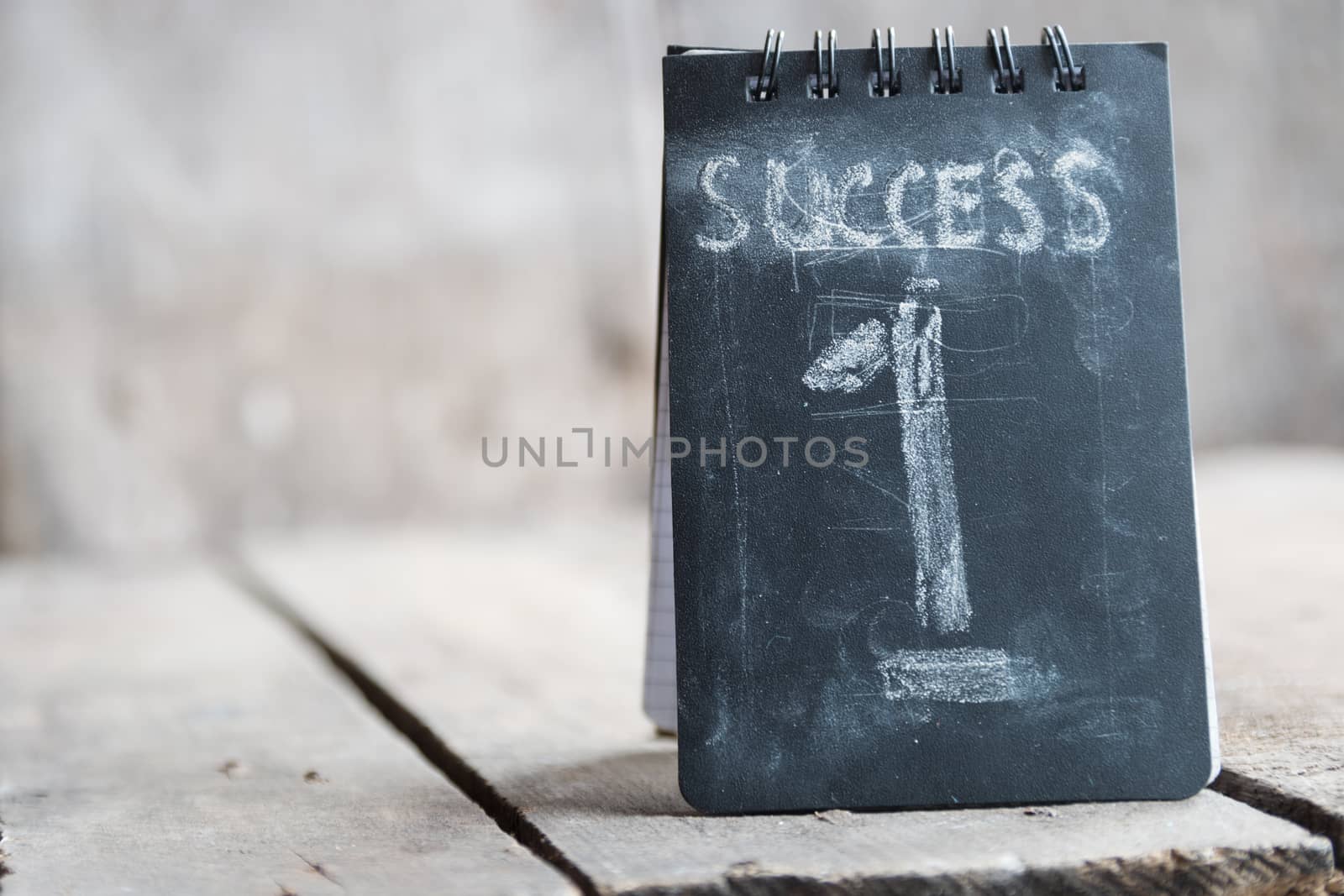 Success concept, chalk inscription and wooden table.