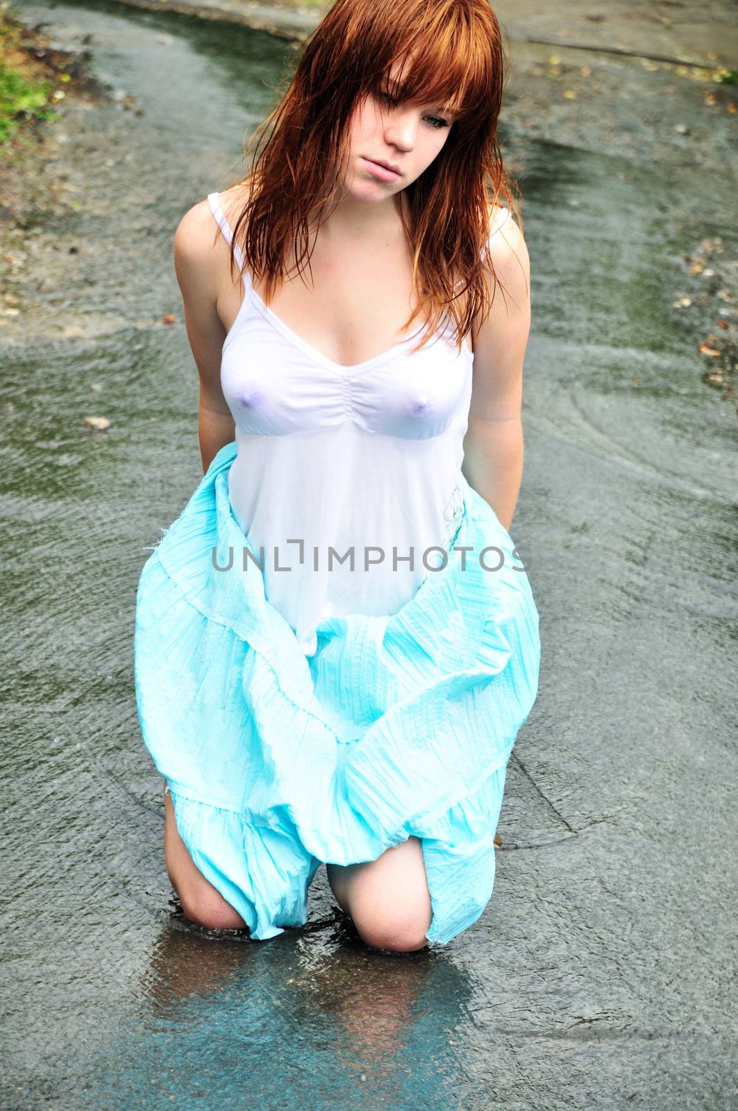 redheaded wet girl sitting in the puddle