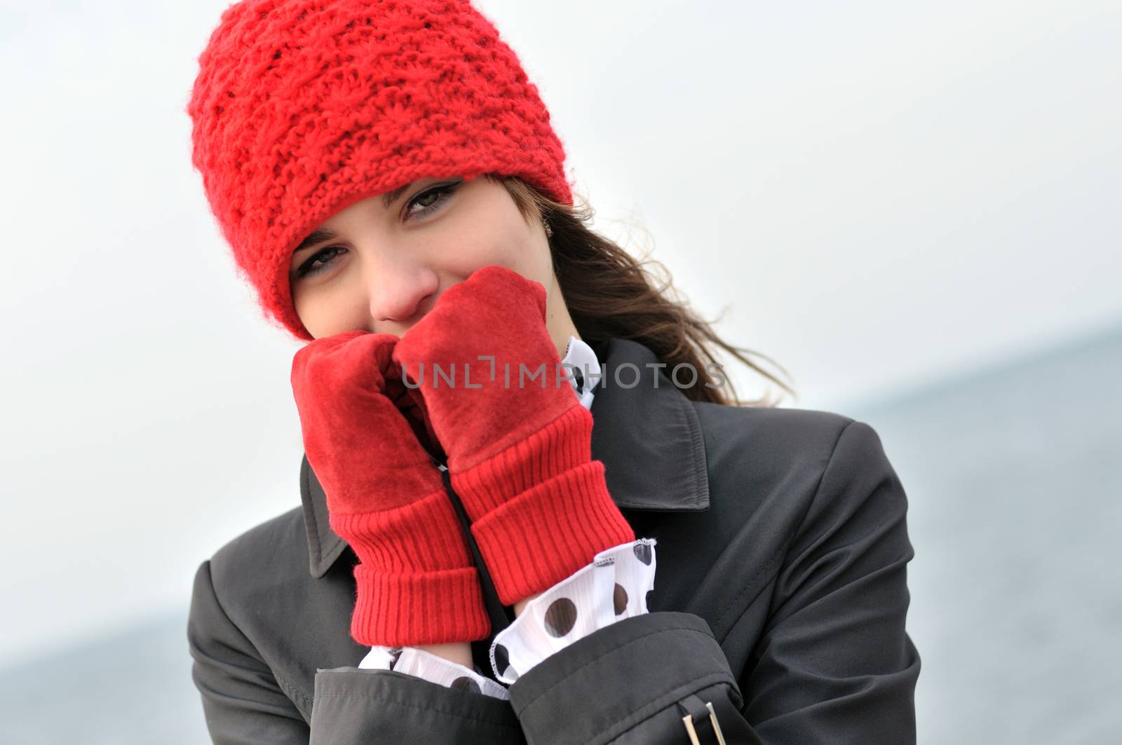 girl wearing  reg hat and red gloves outdors