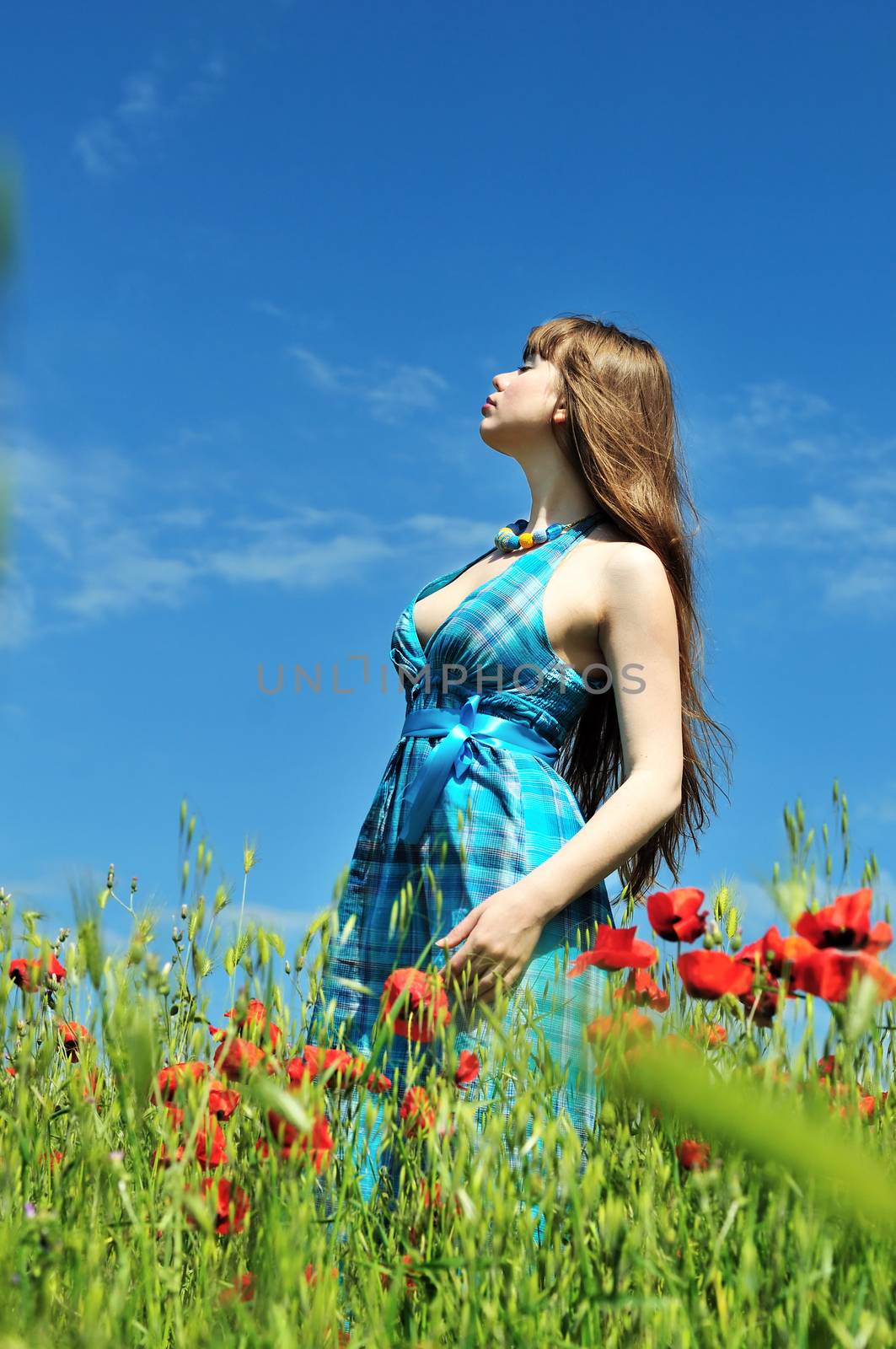 spring beautiful womanenjoying of weather in the poppy field