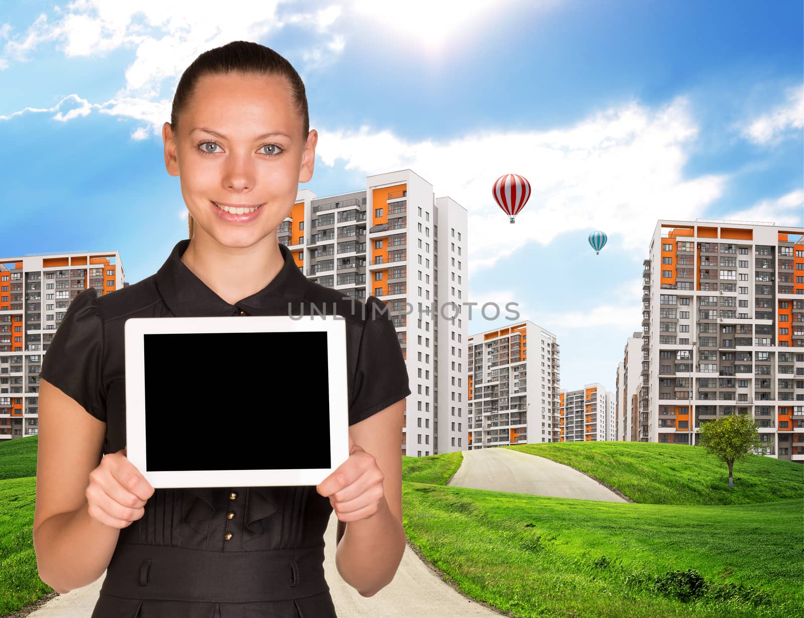 Businesswoman holding tablet and cityscape under blue sky with road and trees