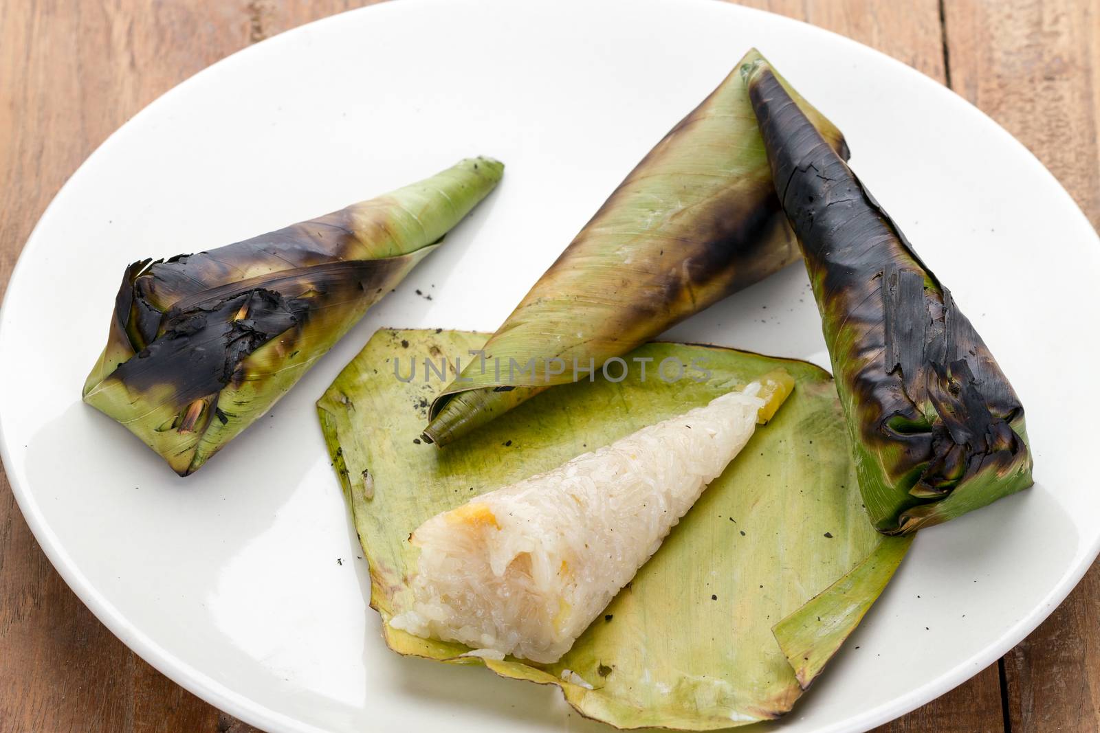 Thai Dessert - Sticky Rice with Sweet Potato wrapped by banana leaf - cooked by Grill on white dish