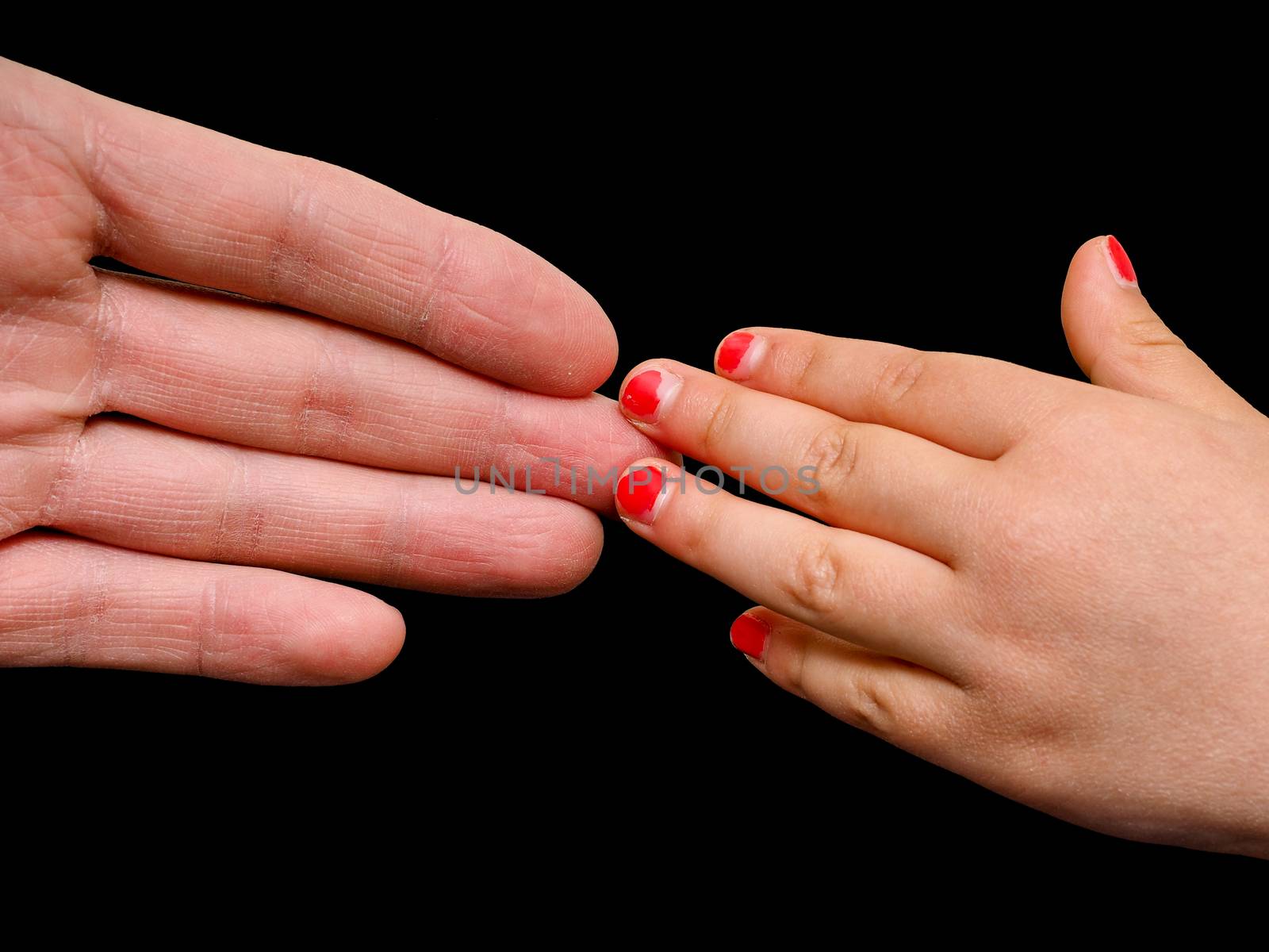 Big hand palm meeting small girl hand with cracked pink nail paint isolated on black