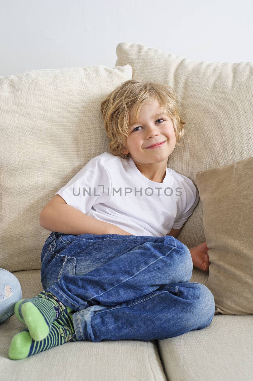 Young boy sitting on sofa looking at camera