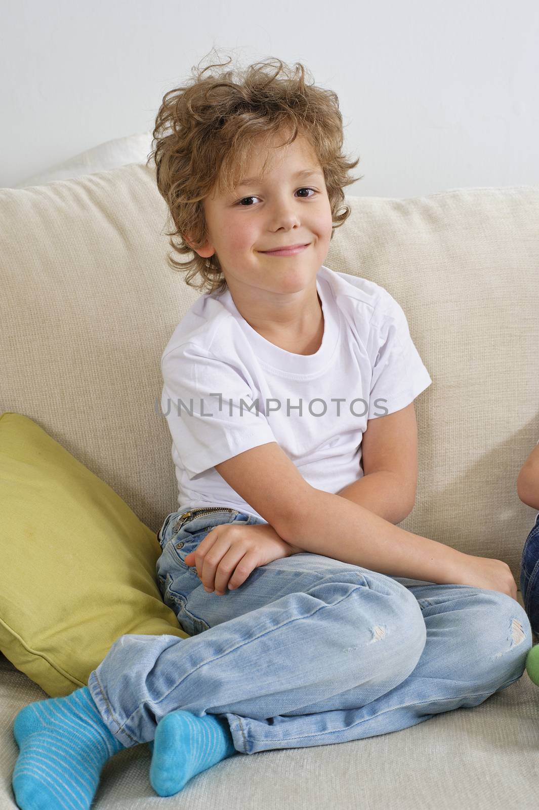 Young boy sitting on sofa looking at camera