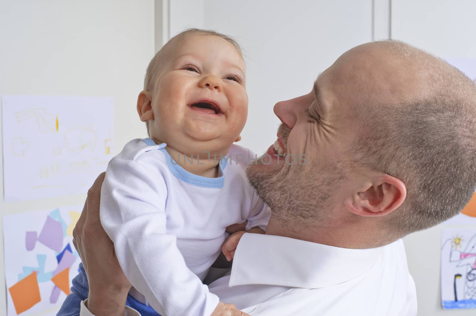 Father holding and playing with his infant son