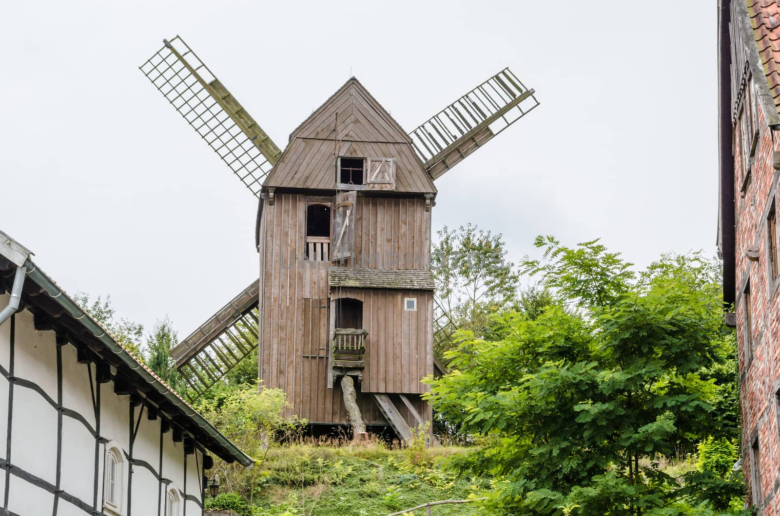 The windmill of Dutch design behind a half-timbered house.
