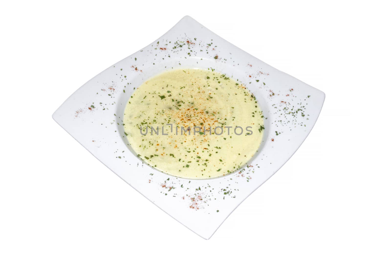 White plate filled with broccoli vegetable soup on white background.