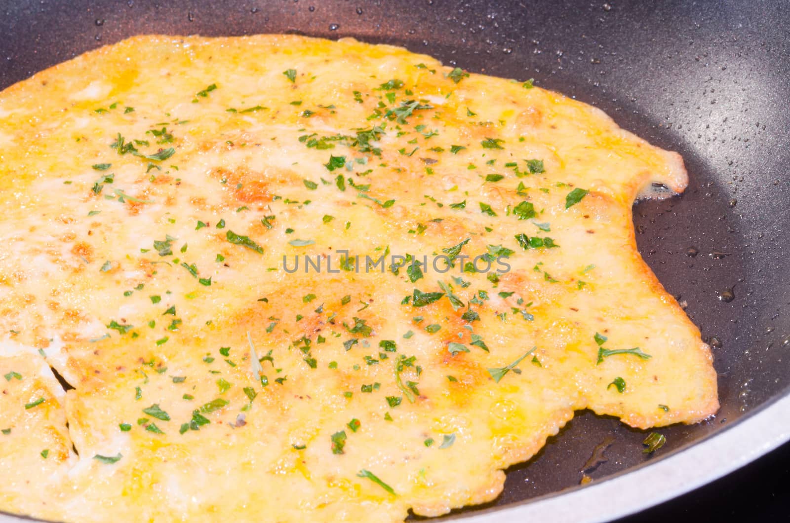 Freshly cooked omelet, pancake in a frying pan.