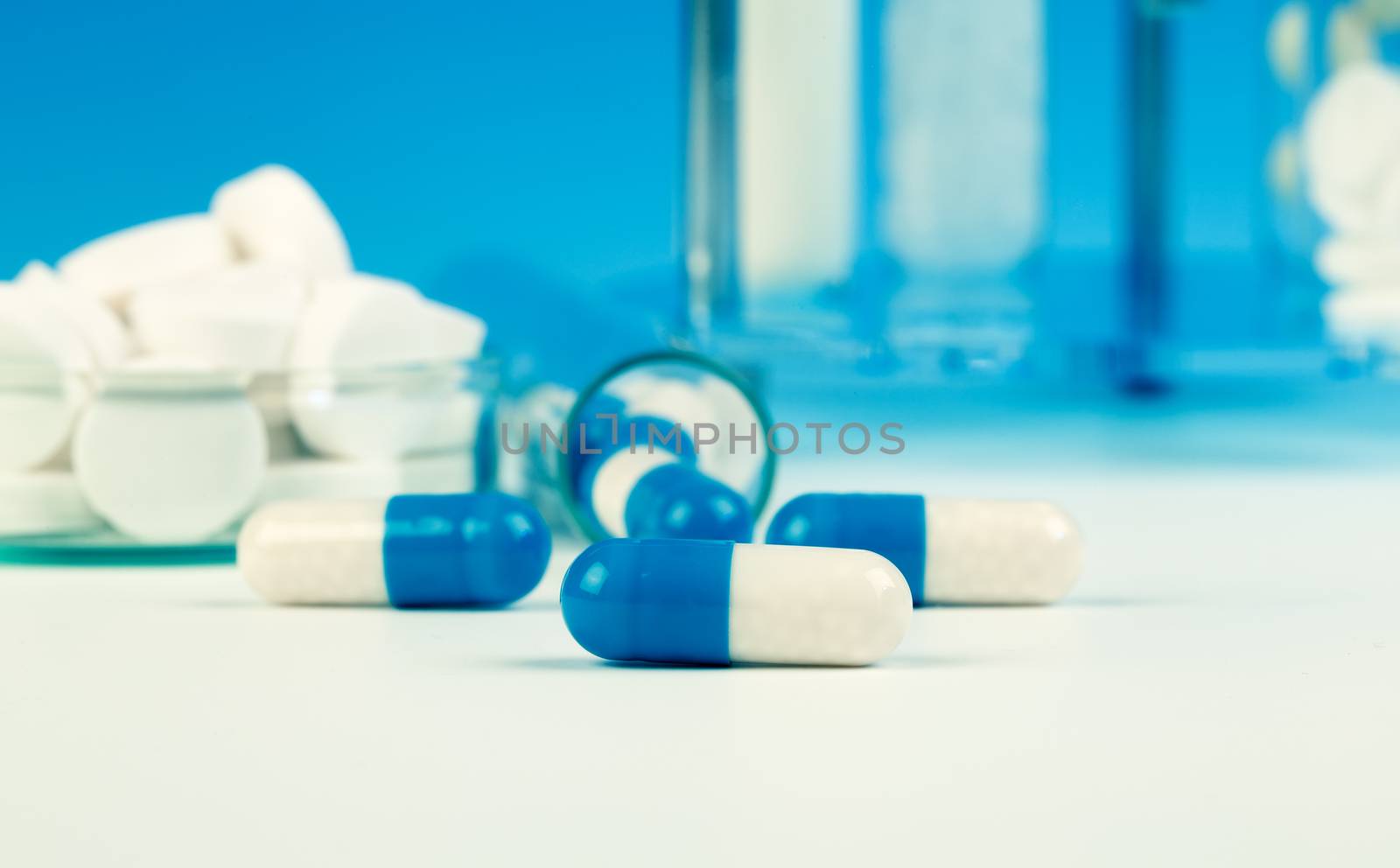 blue medical capsules on white background. by motorolka