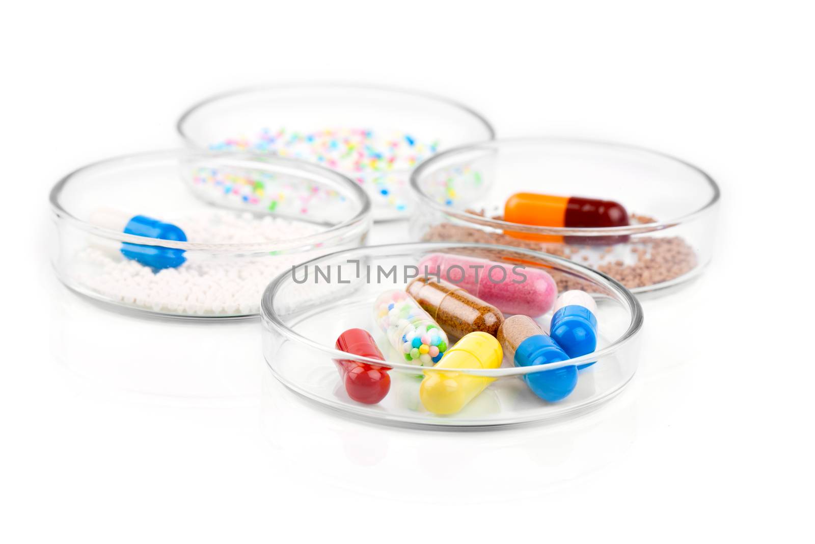 Colorful medical capsules in Petri dishes. Laboratory concept.