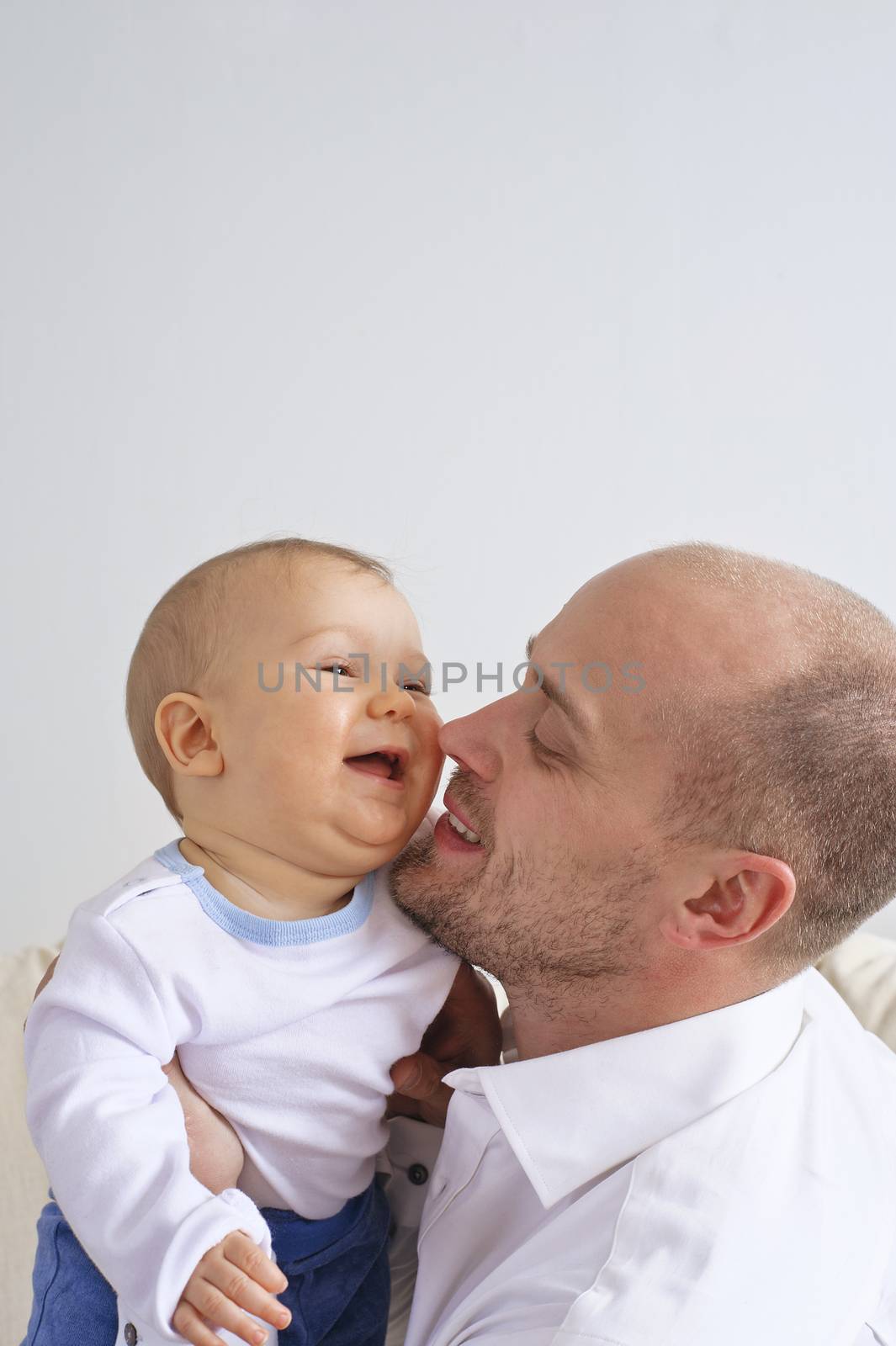 Father holding and playing with his infant son