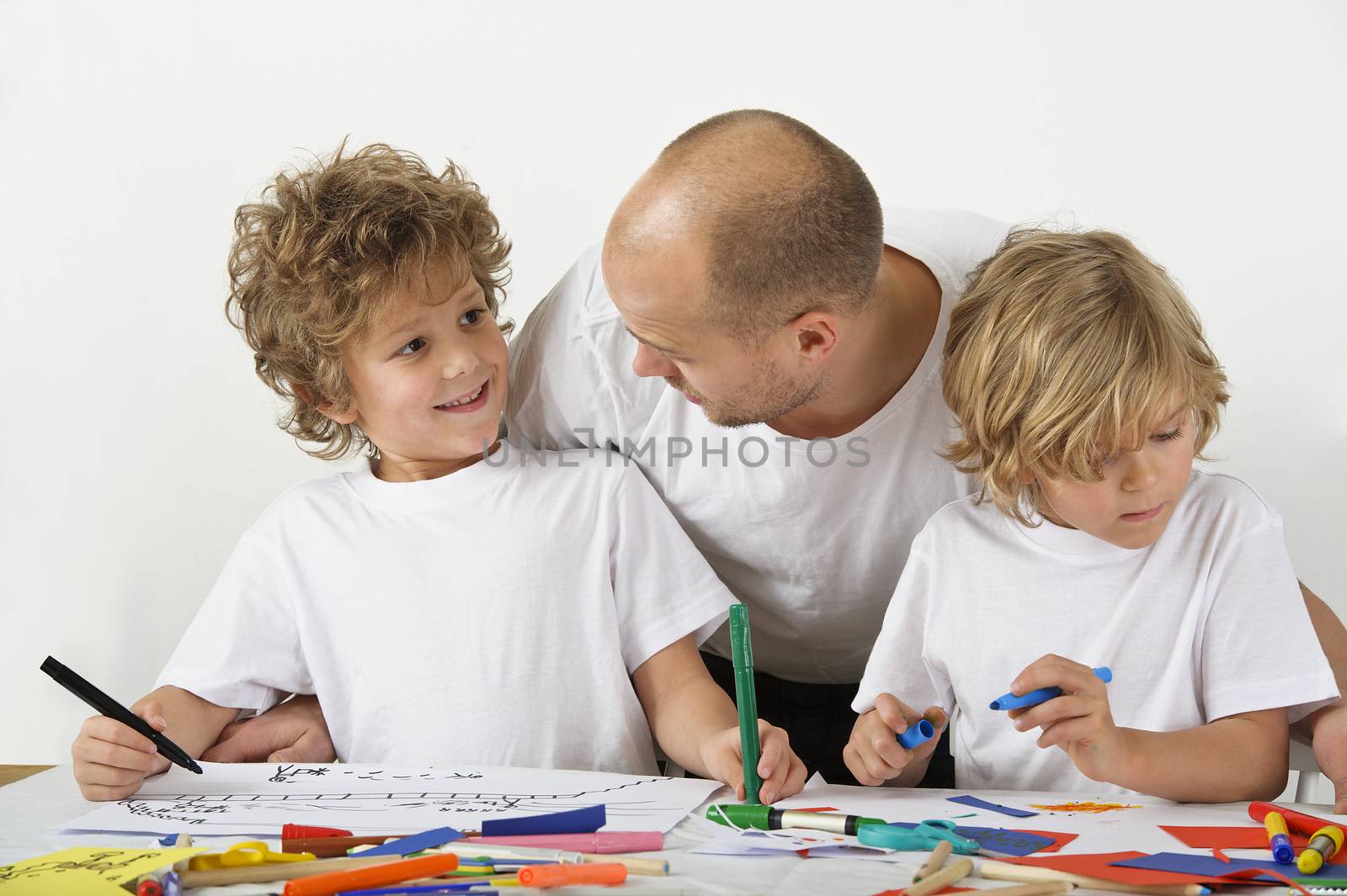 Father teaches his sons how to draw