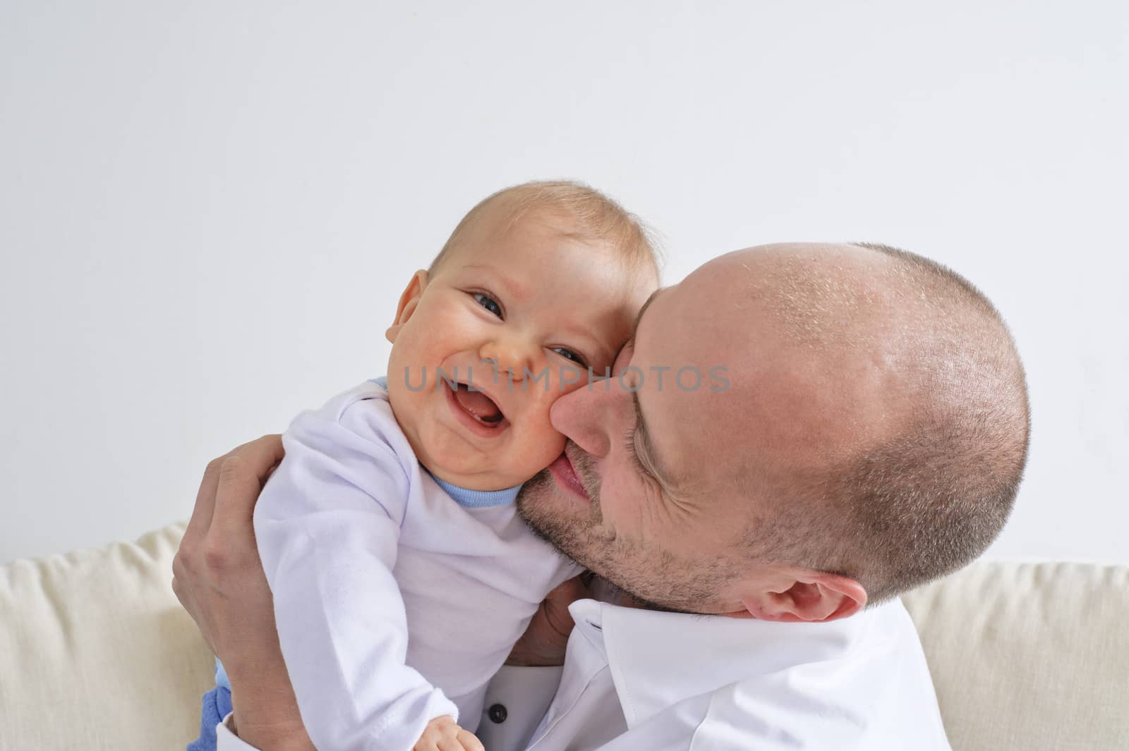 Father holding and playing with his infant son
