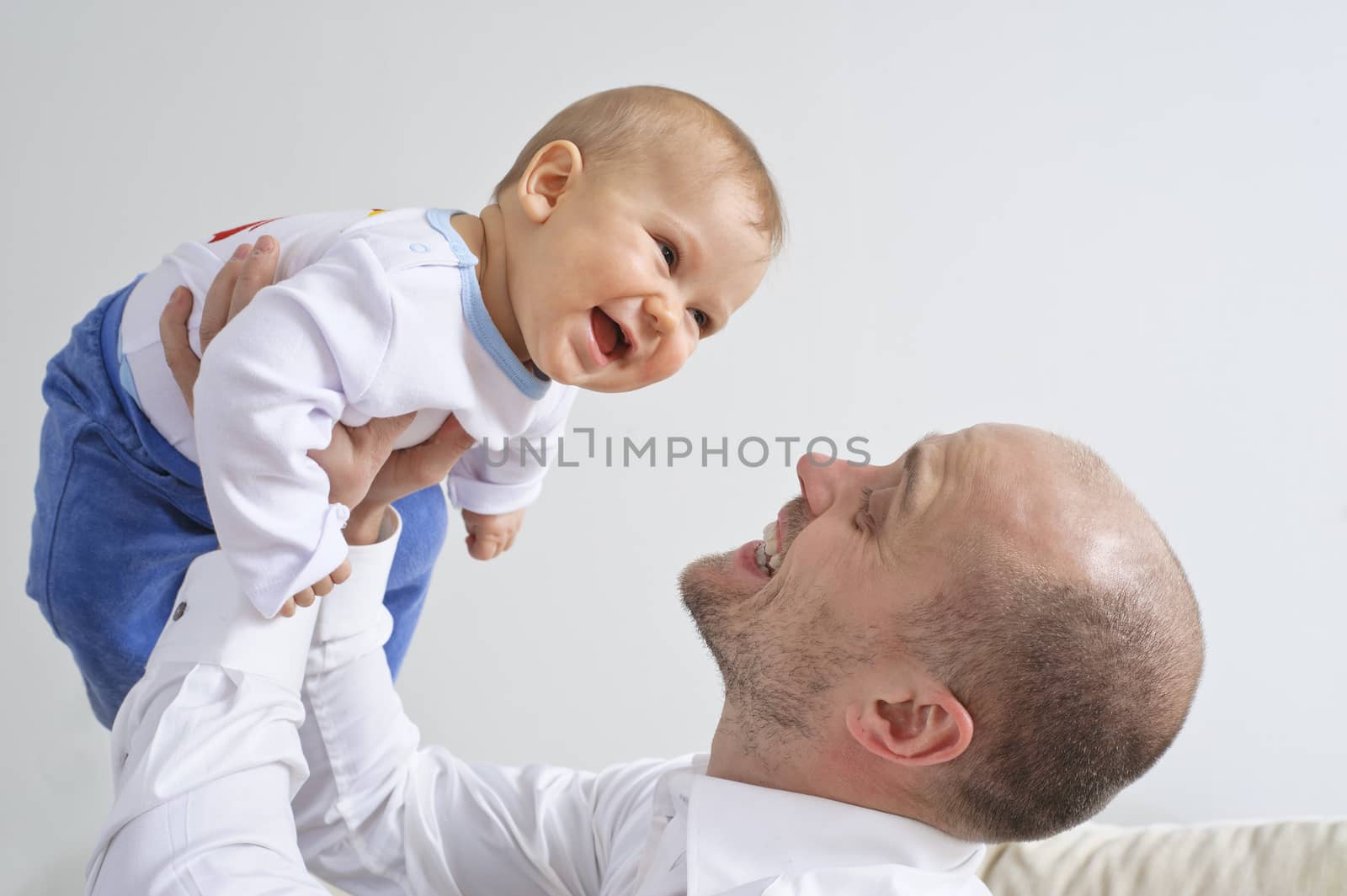 Father holding and playing with his infant son