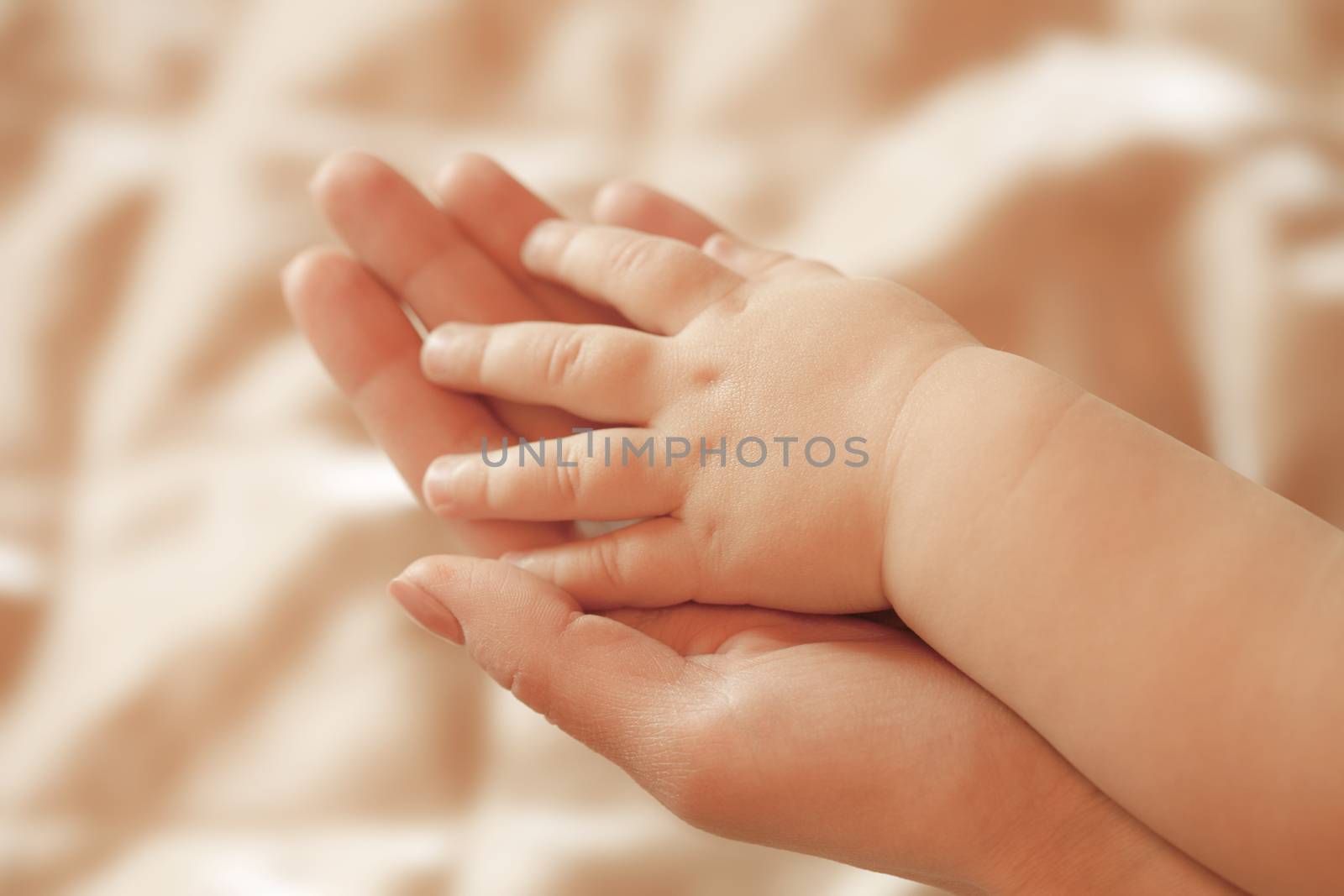 Small children's hand lies on a hand mom