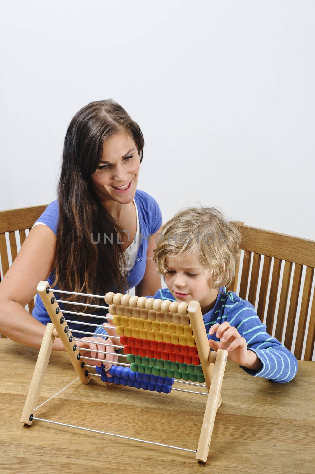 Mother teaches her son how to count using an abacus
