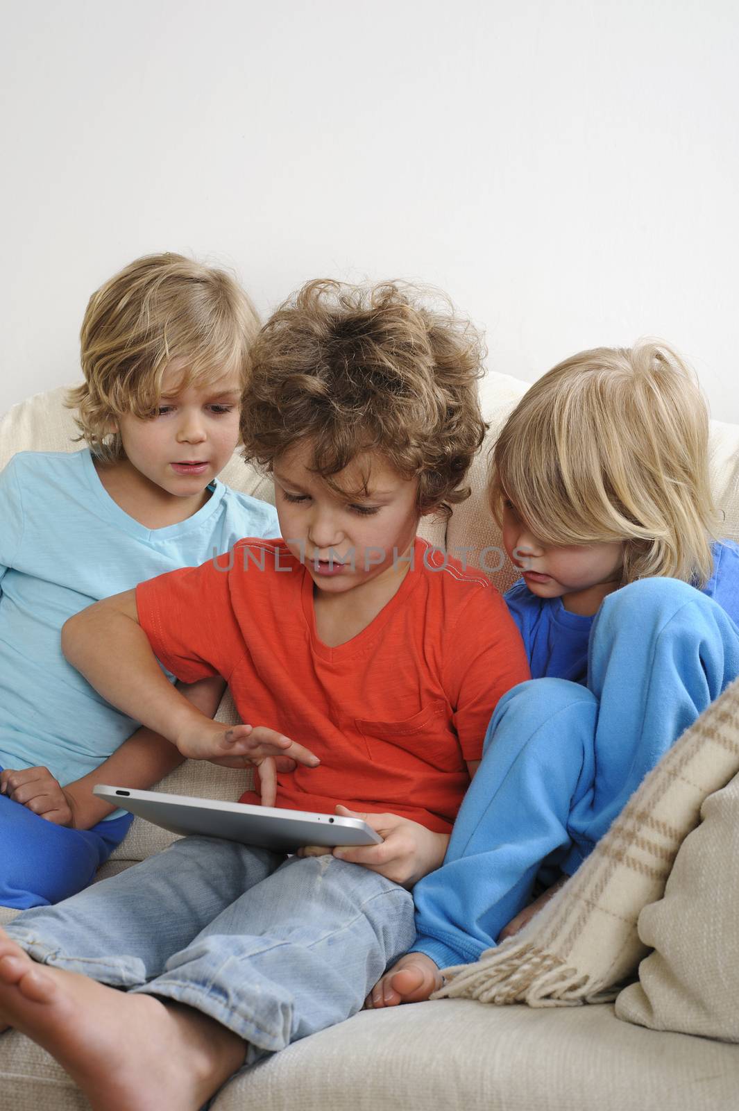 three boys playing with a tablet by brendan_delany