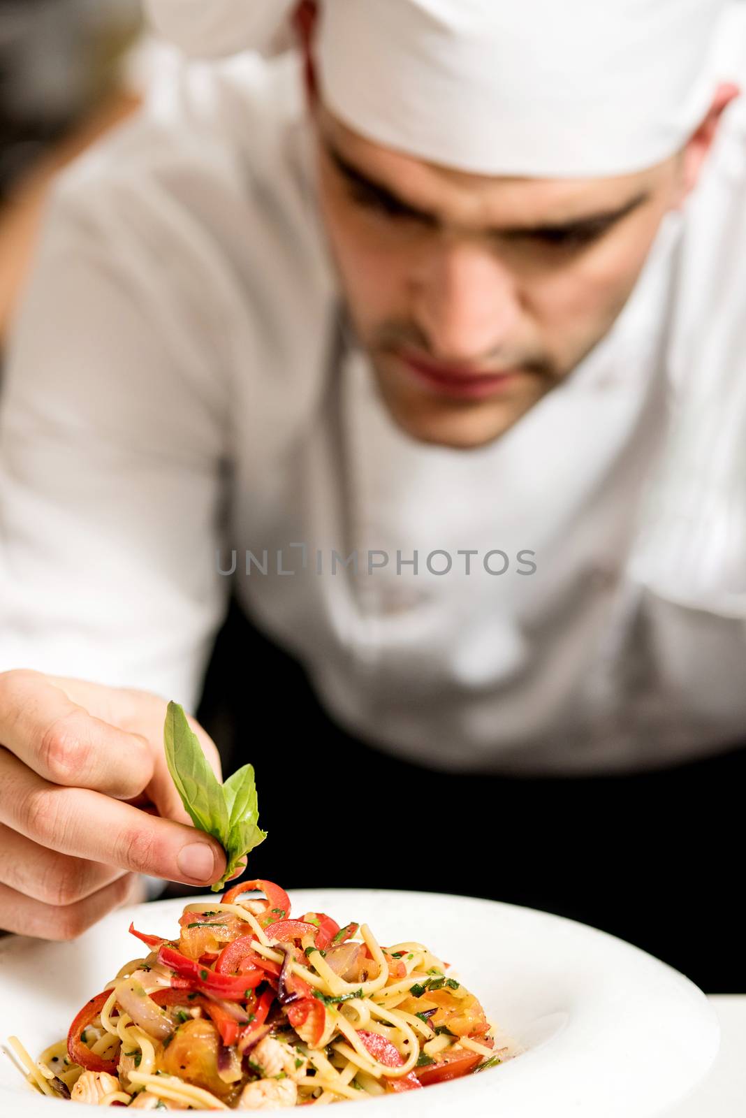 Close up male chef decorating pasta salad