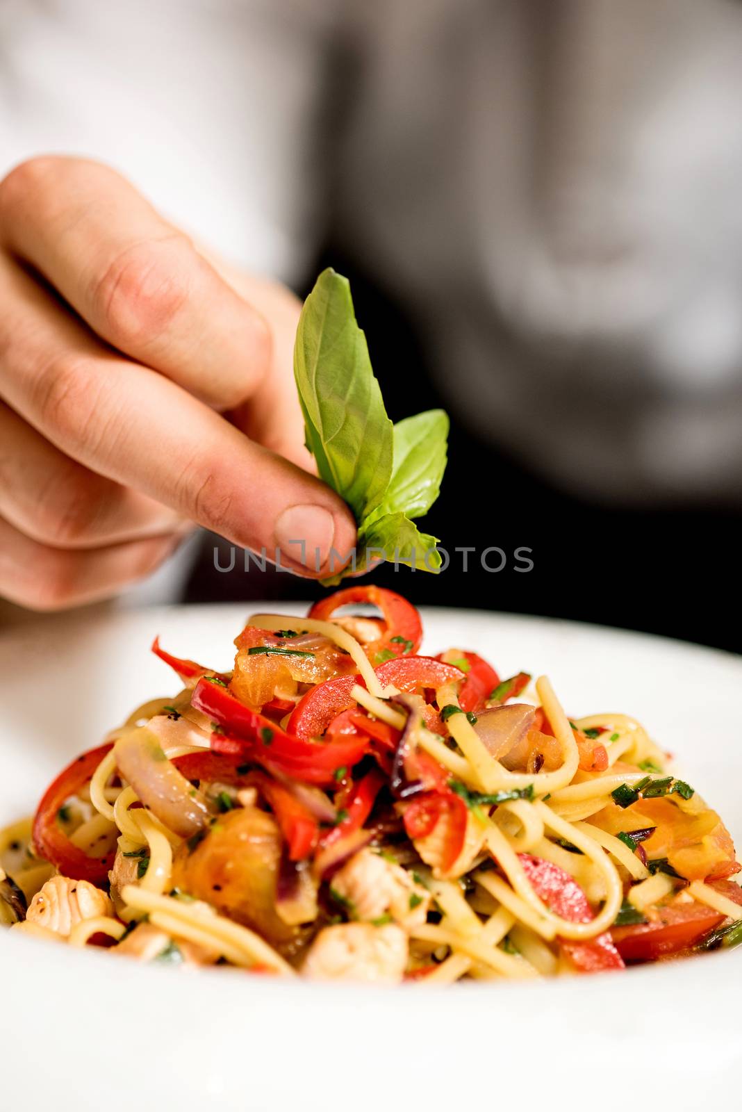 Close up of chef hand decorating pasta salad