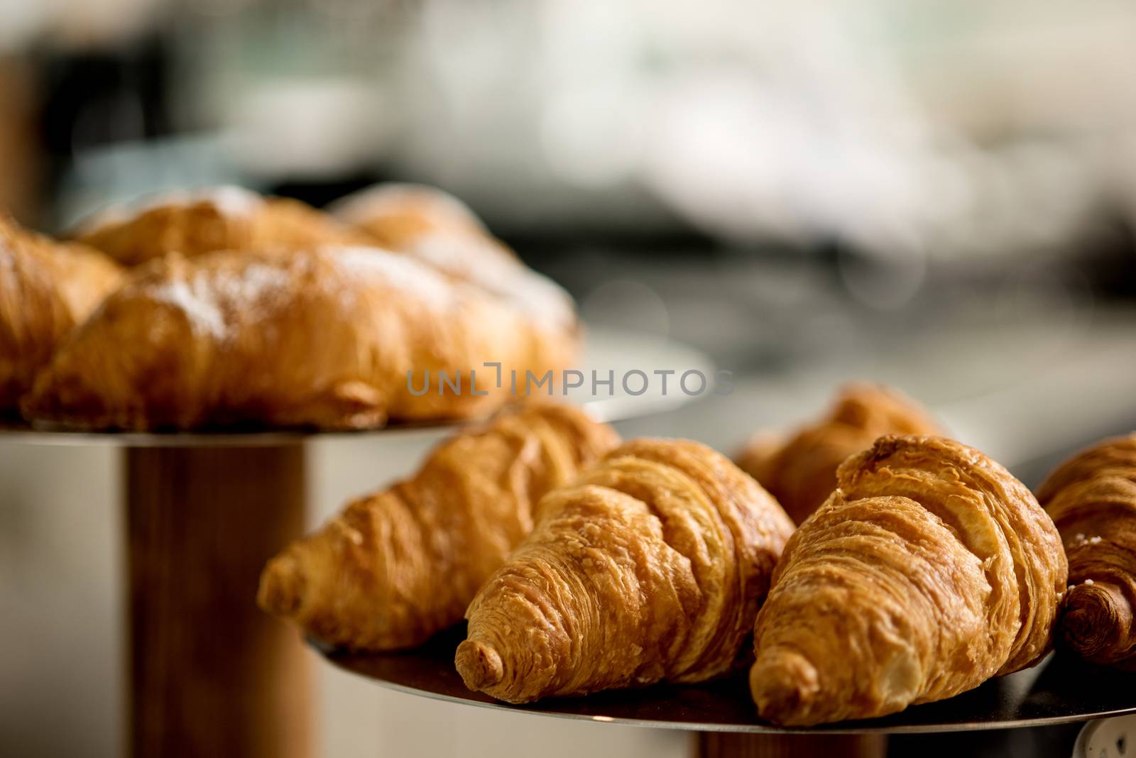 Fresh and tasty croissants displayed on plate. 