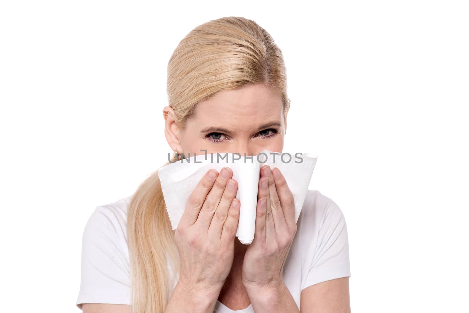 Sick woman blowing her nose into a tissue