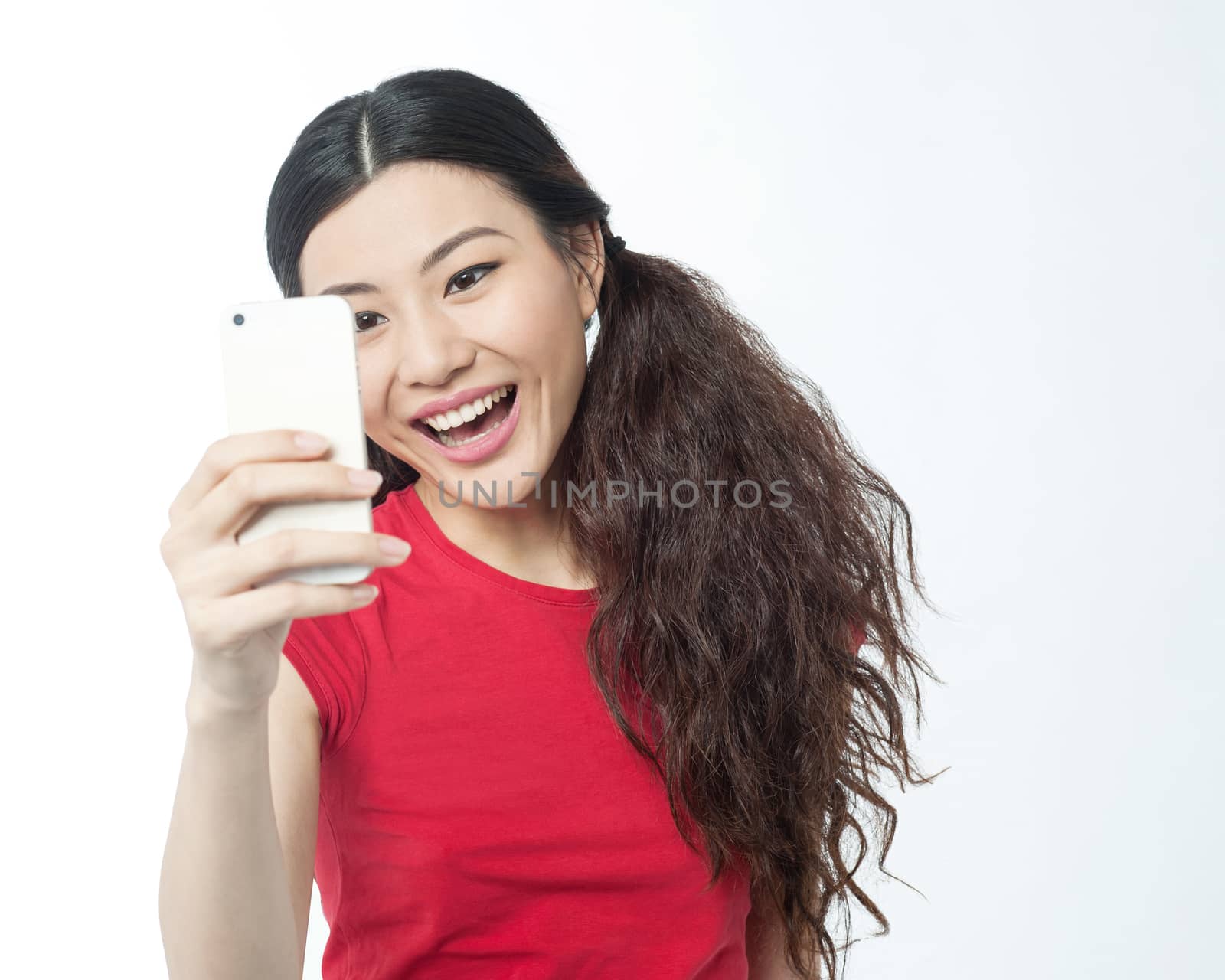 Happy young girl reading a messages in cell phone