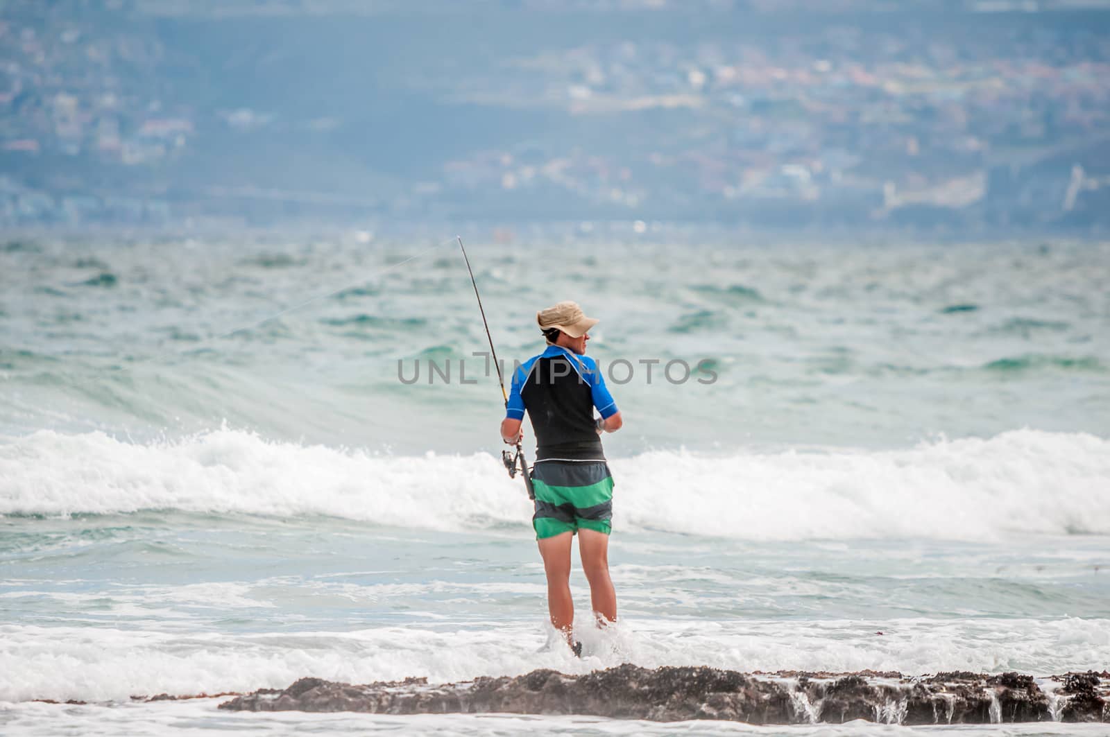 MOSSELBAY, SOUTH AFRICA - DECEMBER 29, 2014: Unidentified angler at a beach in Reebok near Mosselbay, South Africa
