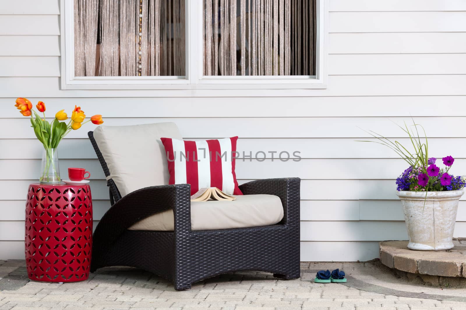 Teatime taking a relaxing break on the outdoor patio in a comfortable deep seating armchair with colorful spring flowers enjoying the seasonal sunshine