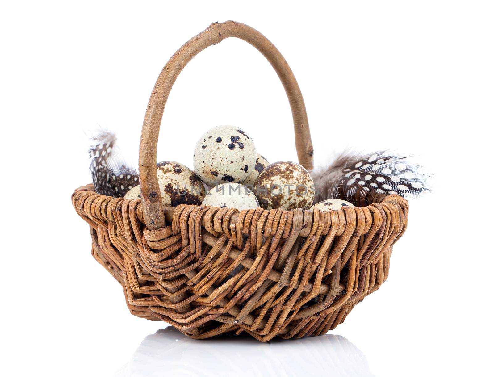 quail eggs in a wicker basket on white background