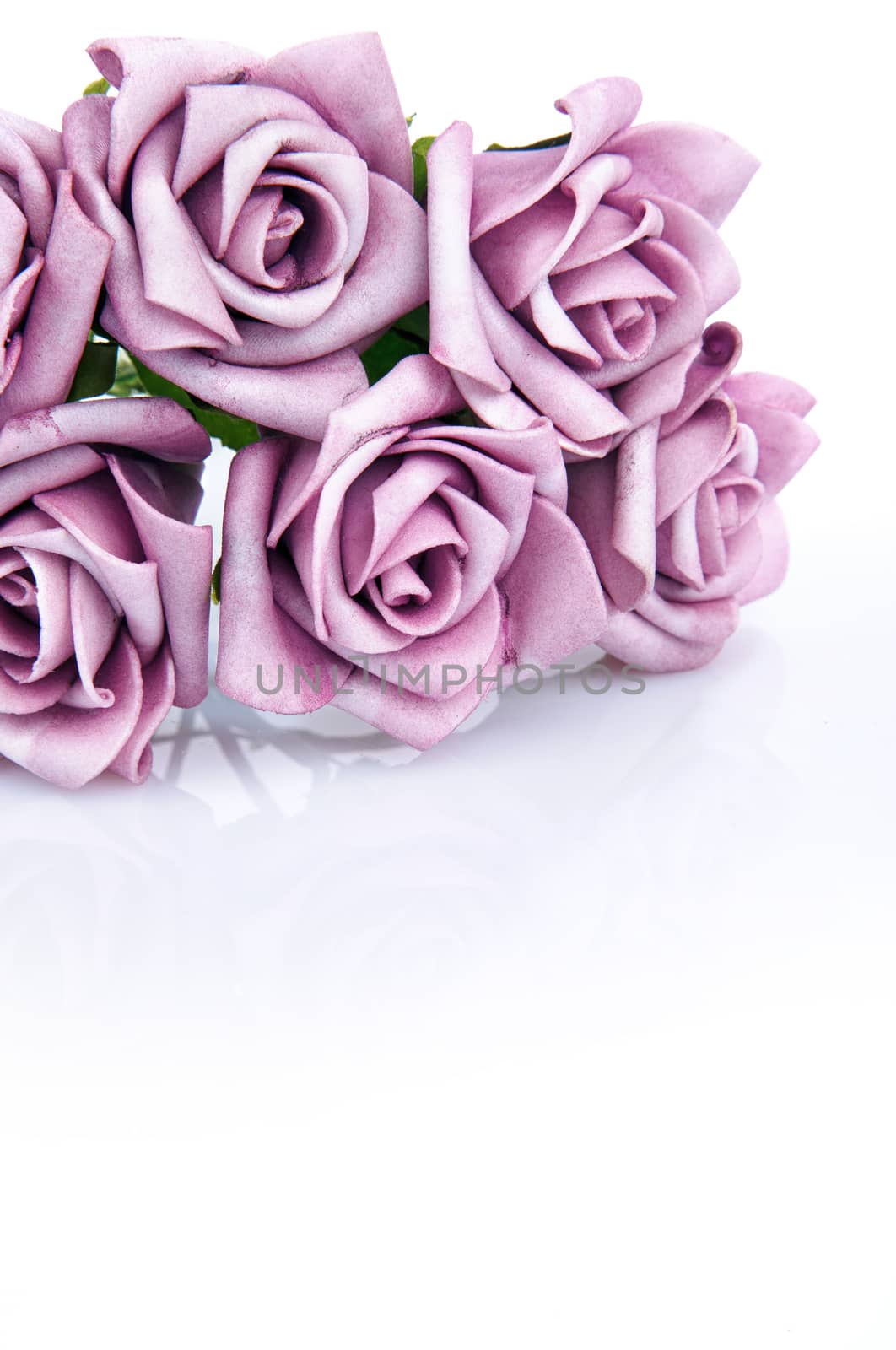 artificial bouquet of purple roses on a white background