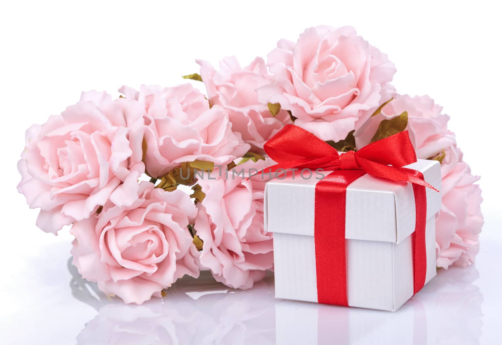 pink flowers and  gift box with red ribbon and bow on a white background