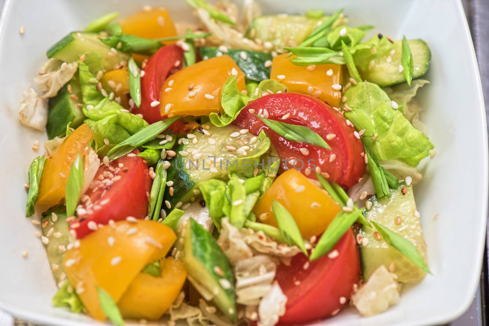 Bulgarian salad from pepper, cucumbers, tomato, green onion with sesame and oil