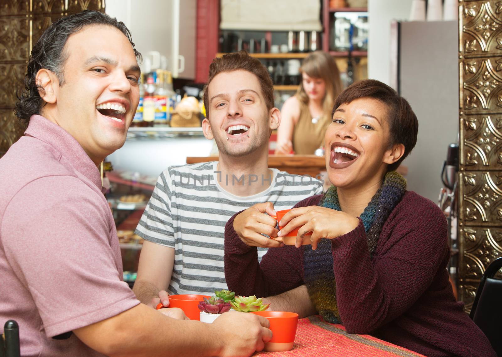 Laughing group of young adults sitting in cafe