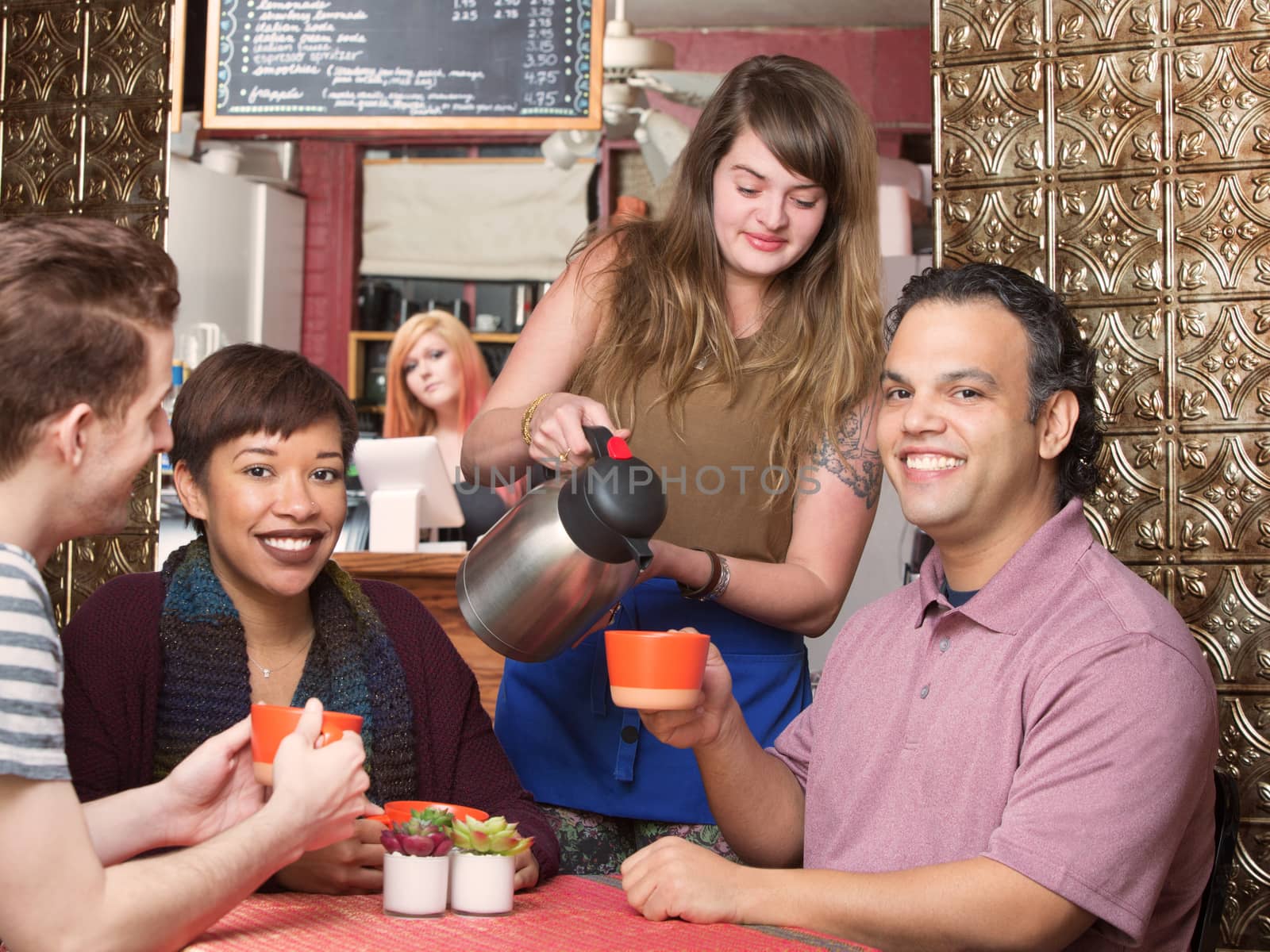 Cute waitress pouring coffee for happy customers