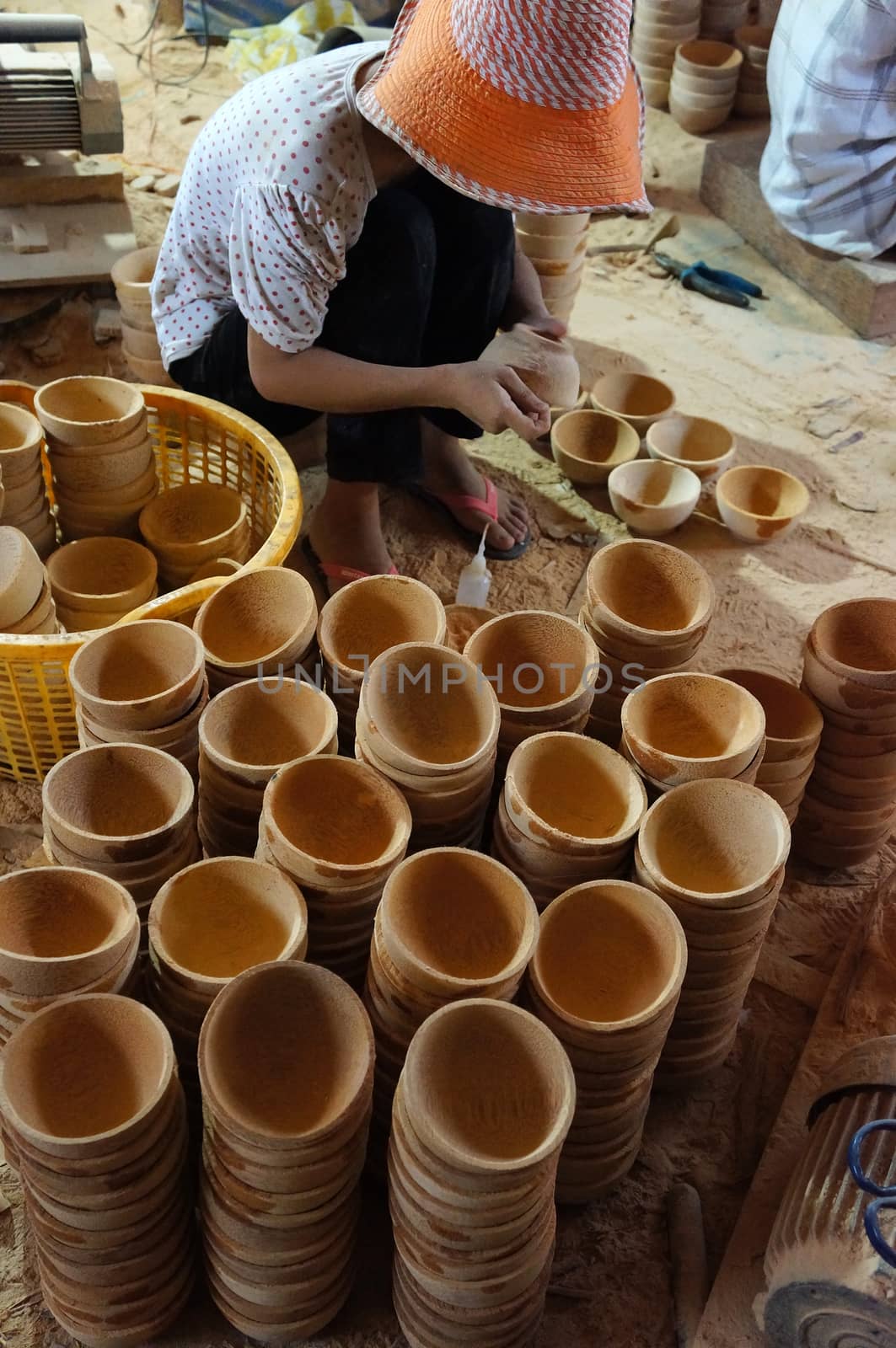 BEN TRE, VIET NAM- JUNE 2: Asian worker working at wood workshop, Vietnamese people make product from coconut tree trunk, tradition craft,  in polluted enviroment, Mekong Delta, Vietnam, June 2, 2015